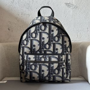 The Rider backpack is a simple, classic, collegiate style with an energetic twist. Crafted in beige and black oversized Oblique print fabrics, it features a new interpretation of the classic Dior motif with smooth cowhide leather detailing and the Dior logo on the front to elevate the classic design. With fine details such as a two-way zipper closure, a large zippered pocket on the front, and adjustable, padded straps, this is the ideal choice for everyday styling. Ideal for everyday stylingOversized Oblique print in beige and blackMetal laminated brass Dior logo at frontEmbossed Dior logo at interiorTwo way zipper closurePadded adjustable shoulder strapLeather top handlesQuilted technical knit reinforcement at back of handbagDior logo embossed on front zipper pocket and interior patch pocketDust bag includedMade in ItalyModel number 8961Size 30-42-15191701300