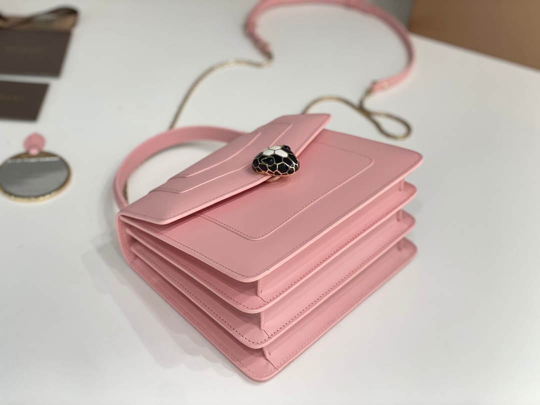 Le sac à main "Serpentine Forever" réinterprète son intemporalité dans des couleurs fraîches et glamour, alliant le style moderne à la polyvalence et au glamour. Ce sac a un corps en cuir de veau rose cerise avec des accessoires en laiton plaqué palladium avec des accessoires en laiton plaqué palladium La tête de serpent en malachite s'adapte facilement aux looks de tous les jours. Bandoulière en cuir détachable et réglable pour plus de polyvalencePetit format avec un petit miroir de courtoisieEtiquette de sécurité au laser et code estampillé individuellementTaille : 20 x 15 x 9,5 cm