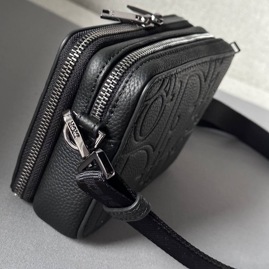 Elegante y práctico, este bolso de mano con cremallera y bandolera puede utilizarse para guardar una gran variedad de objetos de uso diario El cuero estampado Dior Gravity está repujado con un motivo clásico sobre piel de vacuno negra La parte delantera está decorada con el logotipo Dior, un homenaje a la artesanía del atelier Dior La parte superior tiene un cierre de cremallera de doble sentido y los bolsillos con cremallera y forro cosido en forma triangular combinan elegancia y practicidad para elevar el estilo de este bolso. Bandolera ajustable y amovible con logotipo Christian DiorBolso bandolera, bandolera cruzada o clutchInterior de piel de vacuno lisa y nylonCompartimento doble con cremalleraBolsillo interior con 4 ranuras para tarjetasModelo nº 803617-12.5-6Correa de nylon jacquard Christian Dior ajustable y amovible con cierre de langostaRevestimiento metálico en la parte delanteraLogotipo Dior en latónLogotipo Dior en el interior Logotipo en relieveBolsa guardapolvo incluidaFabricado en Europa 19170900-Bolsos de alta calidad