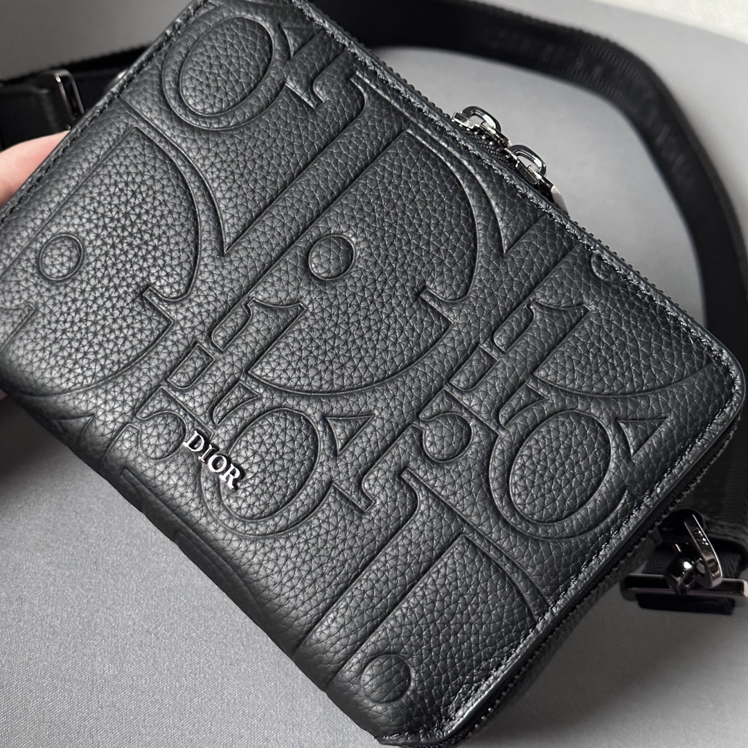 Elegante y práctico, este bolso de mano con cremallera y bandolera puede utilizarse para guardar una gran variedad de objetos de uso diario El cuero estampado Dior Gravity está repujado con un motivo clásico sobre piel de vacuno negra La parte delantera está decorada con el logotipo Dior, un homenaje a la artesanía del atelier Dior La parte superior tiene un cierre de cremallera de doble sentido y los bolsillos con cremallera y forro cosido en forma triangular combinan elegancia y practicidad para elevar el estilo de este bolso. Bandolera ajustable y amovible con logotipo Christian DiorBolso bandolera, bandolera cruzada o clutchInterior de piel de vacuno lisa y nylonCompartimento doble con cremalleraBolsillo interior con 4 ranuras para tarjetasModelo nº 803617-12.5-6Correa de nylon jacquard Christian Dior ajustable y amovible con cierre de langostaRevestimiento metálico en la parte delanteraLogotipo Dior en latónLogotipo Dior en el interior Logotipo en relieveBolsa guardapolvo incluidaFabricado en Europa 19170900-Bolsos de alta calidad