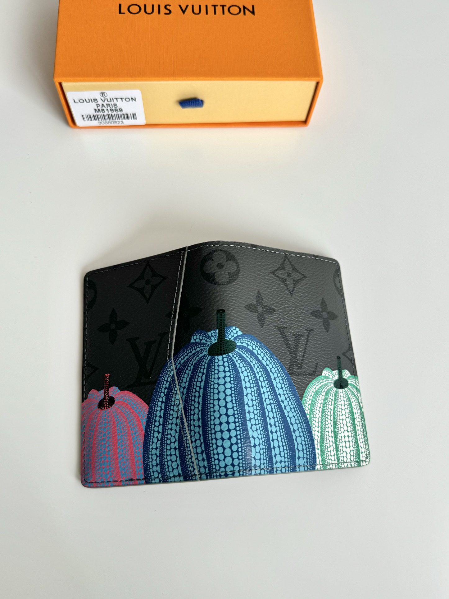 P360 M81969 Esta carteira de bolso LV x YK faz parte da colaboração Louis Vuitton x Yayoi Kusama. O motivo de abóbora colorido na tela Monclerogram Eclipse Reverse recria um símbolo de calor e consolo aos olhos da célebre artista japonesa.