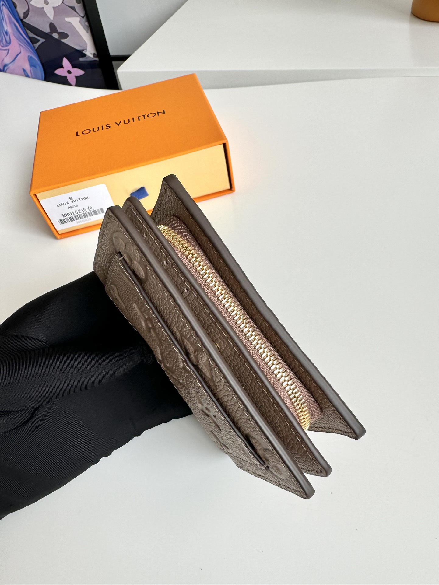 P480 M80152 Black Ce portefeuille Cléa est réalisé en cuir de vachette grainé Monclerogram Empreinte avec l'embossage Monclerogram emblématique de Louis Vuitton pour un design élégant et sophistiqué. Il est petit et spacieux avec une poche plaquée, une poche zippée pour la monnaie, un compartiment pour les billets et six fentes pour les cartes de crédit.