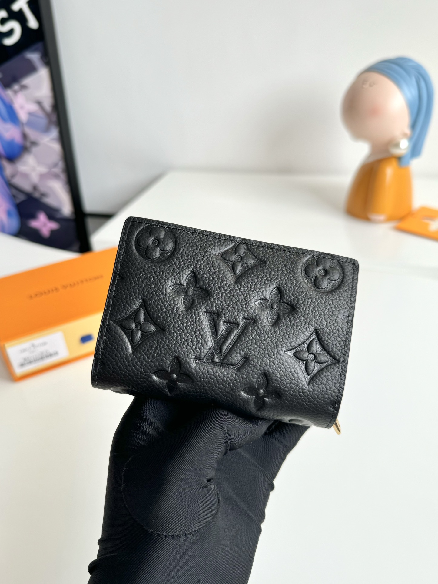 P480 M80152 Preto Esta carteira Cléa é fabricada em pele de vaca Monclerogram Empreinte de grão suave com o emblemático relevo Monclerogram da Louis Vuitton para um design elegante e sofisticado. É pequena e espaçosa com um bolso de remendo, um bolso com fecho para moedas, um compartimento para notas e seis ranhuras para cartões de crédito.