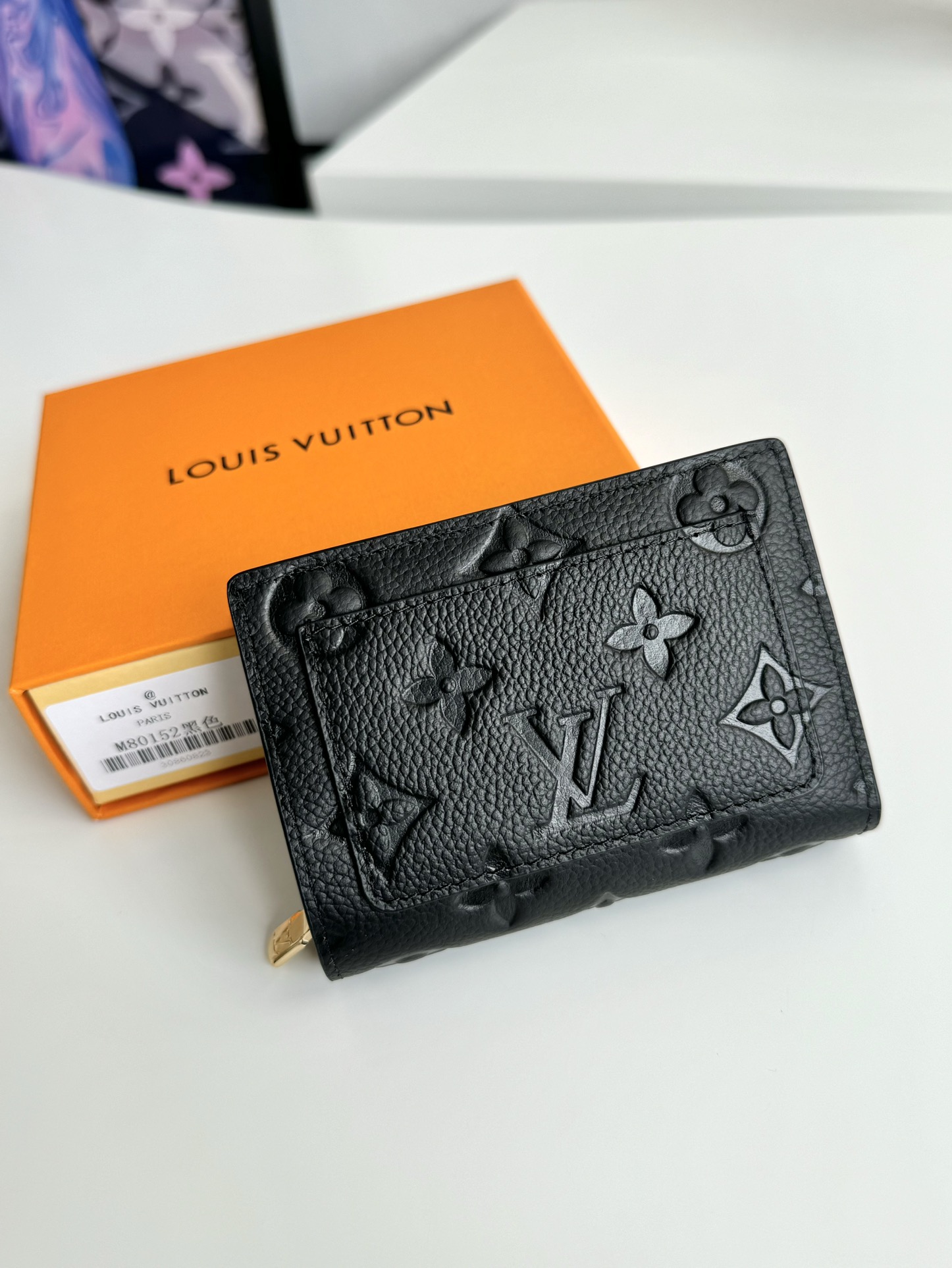 P480 M80152 Preto Esta carteira Cléa é fabricada em pele de vaca Monclerogram Empreinte de grão suave com o emblemático relevo Monclerogram da Louis Vuitton para um design elegante e sofisticado. É pequena e espaçosa com um bolso de remendo, um bolso com fecho para moedas, um compartimento para notas e seis ranhuras para cartões de crédito.