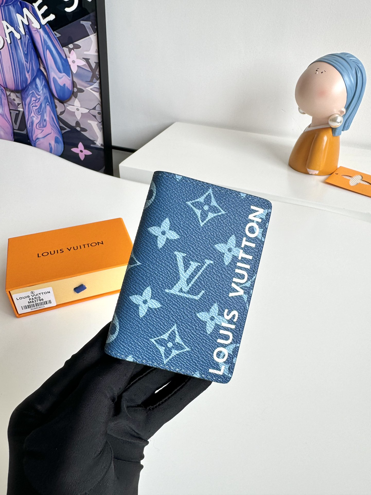 P360 M82796 This pocket wallet is made of smooth Monclerogram-coated canvas with a contrasting color lining and Louis Vuitton lettering on the side in portrait orientation. Its compact shape conceals a wealth of functions.