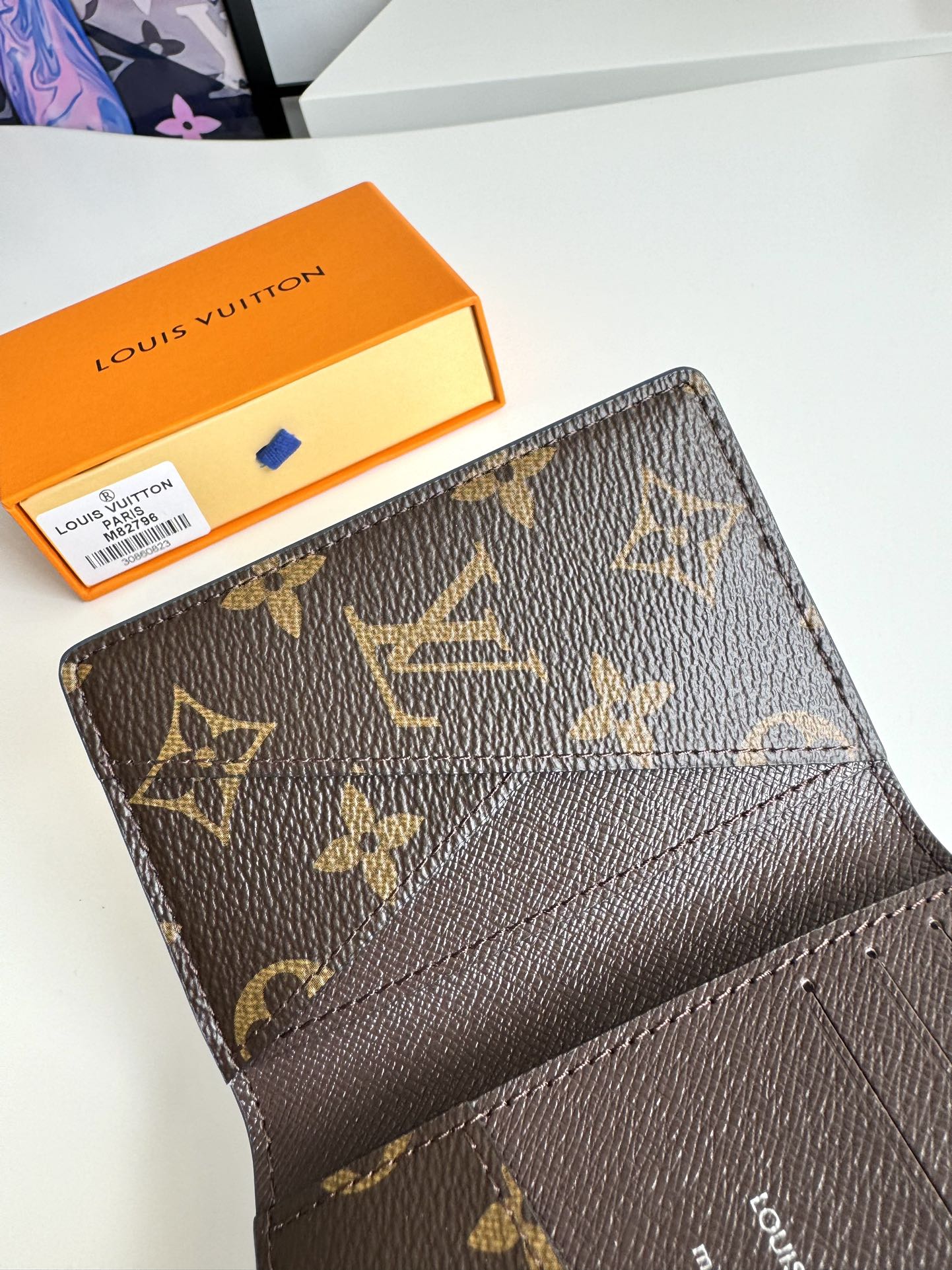 P360 M82796 This pocket wallet is made of smooth Monclerogram-coated canvas with a contrasting color lining and Louis Vuitton lettering on the side in portrait orientation. Its compact shape conceals a wealth of functions.