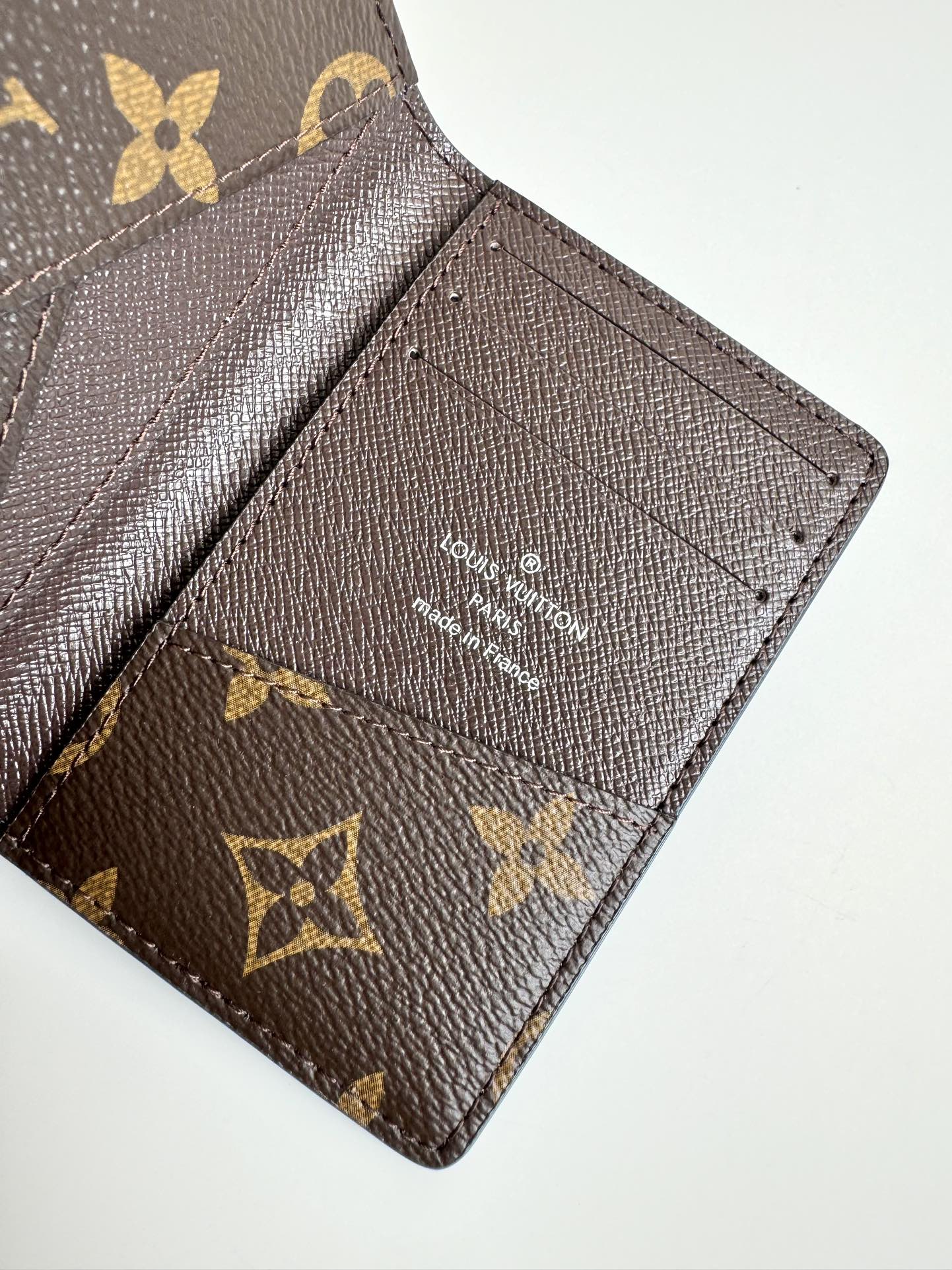 P360 M82796 This pocket wallet is made of smooth Monclerogram-coated canvas with a contrasting color lining and Louis Vuitton lettering on the side in portrait orientation. Its compact shape conceals a wealth of functions.