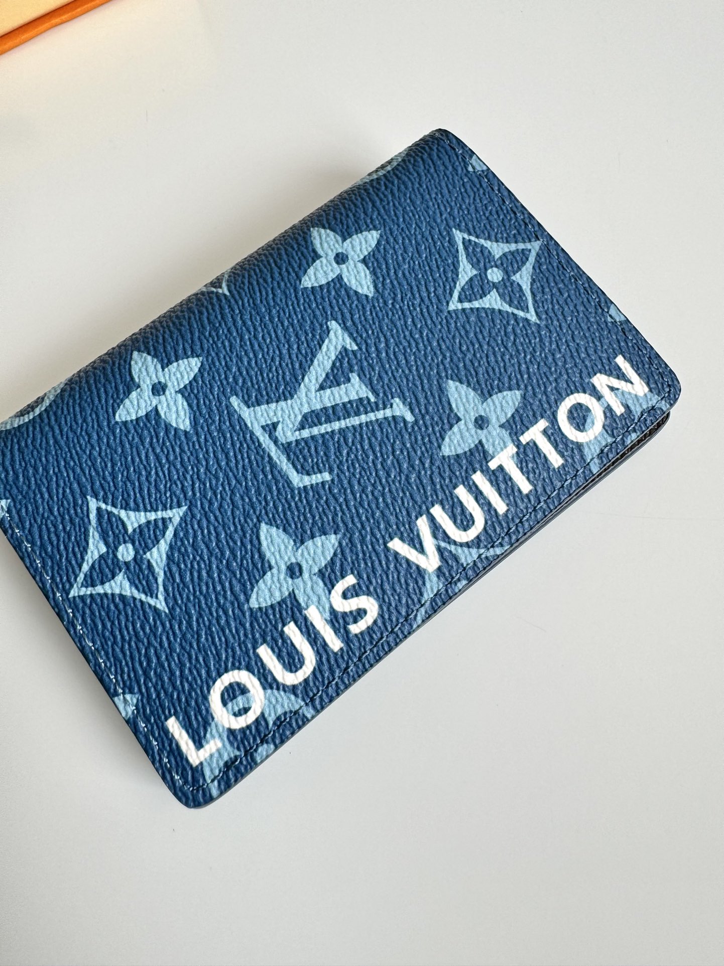 P360 M82796 This pocket wallet is made of smooth Monclerogram-coated canvas with a contrasting color lining and Louis Vuitton lettering on the side in portrait orientation. Its compact shape conceals a wealth of functions.