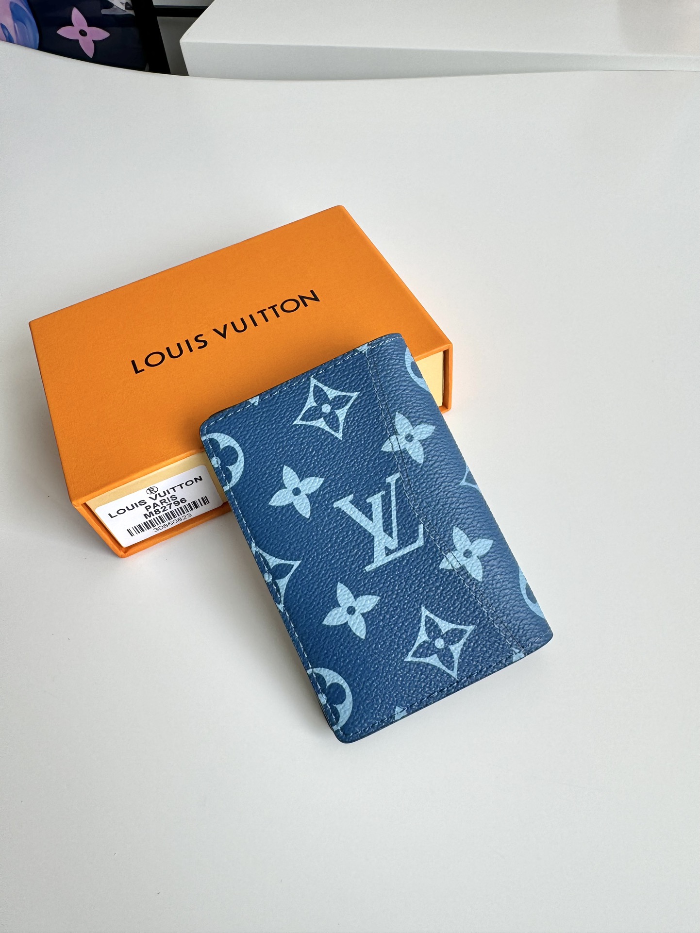 P360 M82796 This pocket wallet is made of smooth Monclerogram-coated canvas with a contrasting color lining and Louis Vuitton lettering on the side in portrait orientation. Its compact shape conceals a wealth of functions.