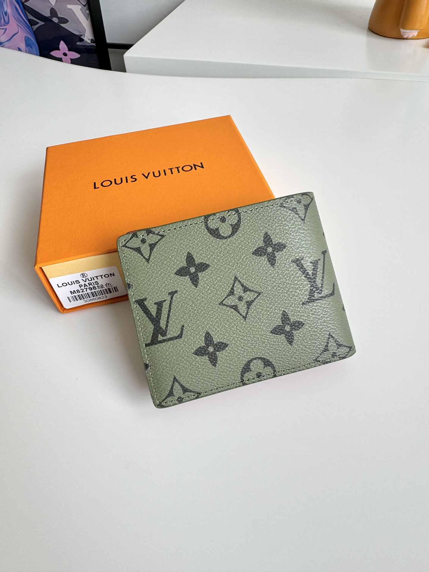 P400 M82798 This Slender wallet is made of Monclerogram canvas with a Monclerogram pattern in different shades on the inside and the Louis Vuitton logo written on the front side of the wallet.