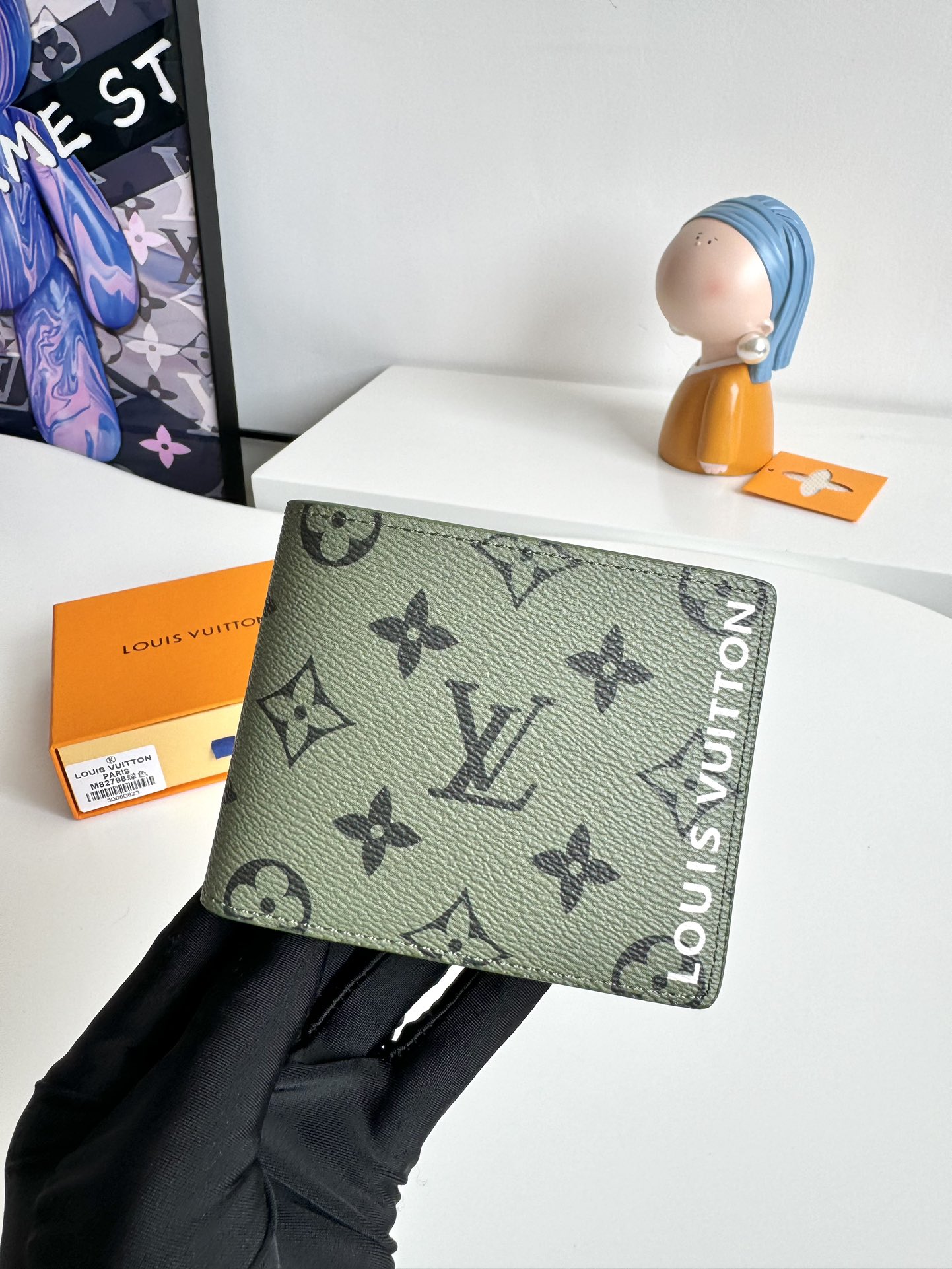 P400 M82798 This Slender wallet is made of Monclerogram canvas with a Monclerogram pattern in different shades on the inside and the Louis Vuitton logo written on the front side of the wallet.