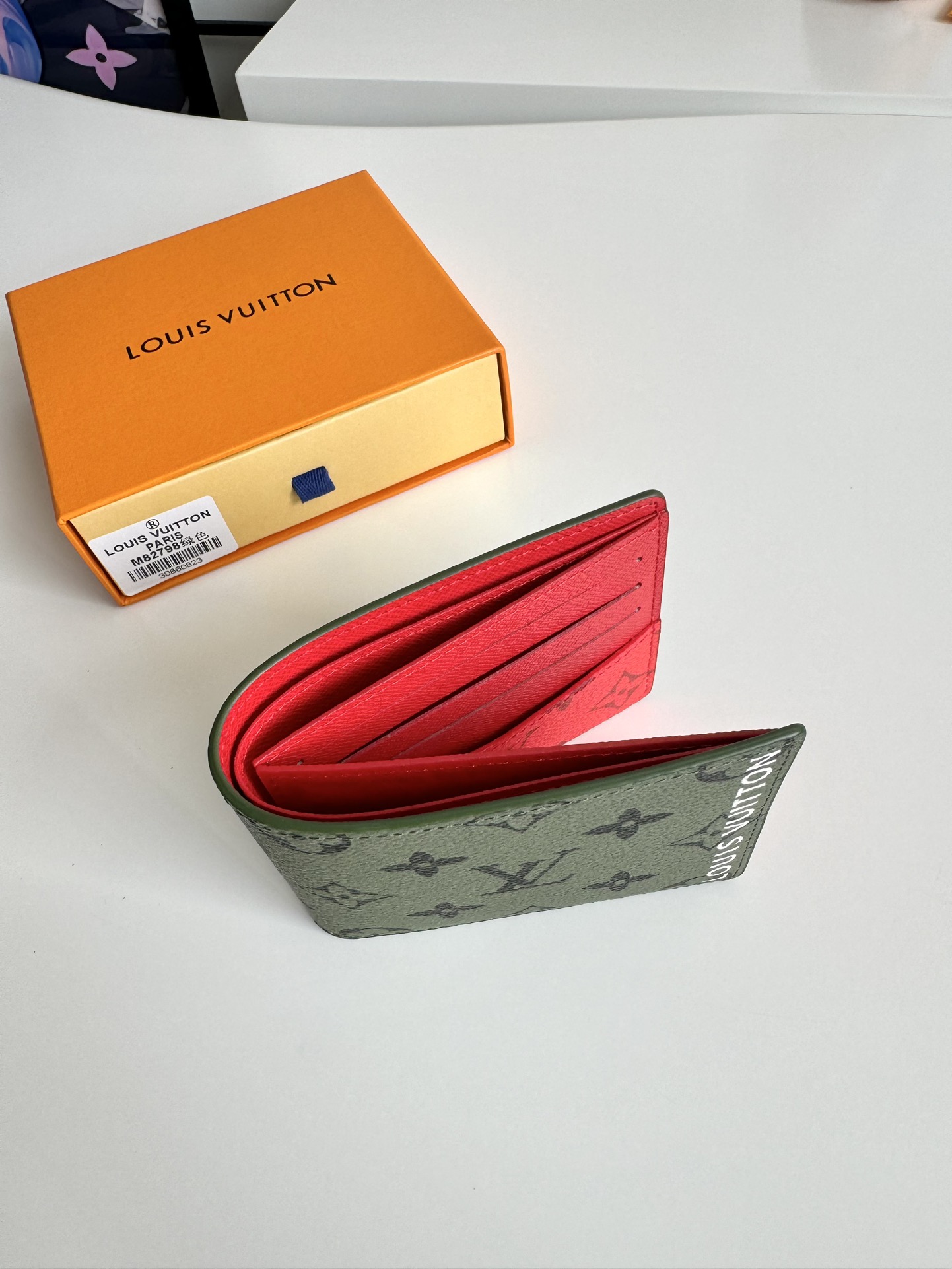 P400 M82798 This Slender wallet is made of Monclerogram canvas with a Monclerogram pattern in different shades on the inside and the Louis Vuitton logo written on the front side of the wallet.