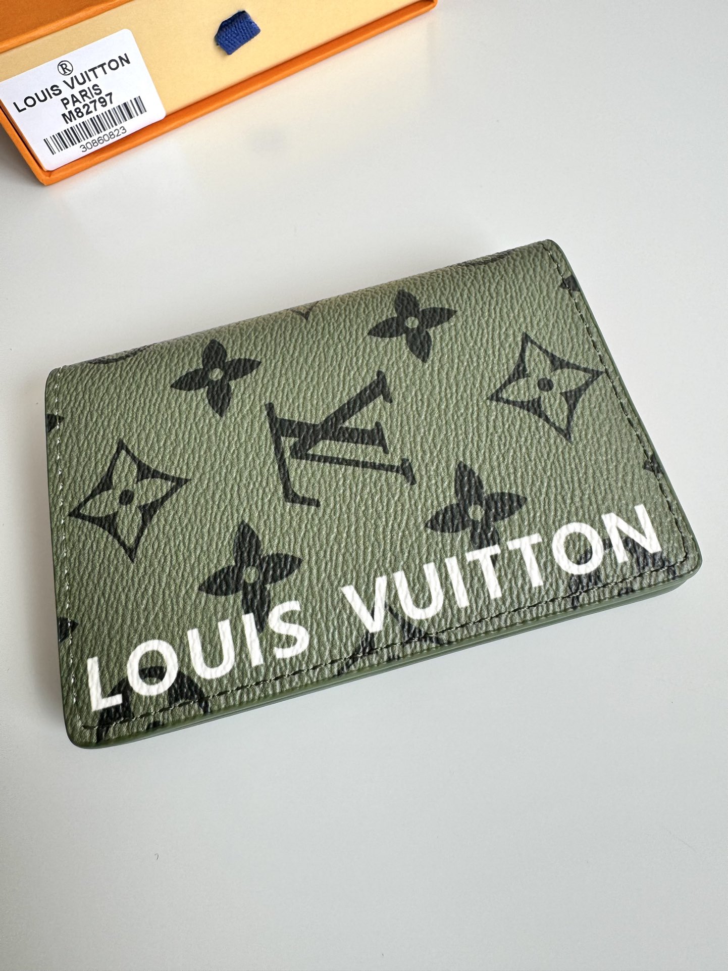 P360 M82797 This pocket wallet is made of smooth Monclerogram-coated canvas with a contrasting color lining and Louis Vuitton lettering on the side in portrait orientation. Its compact shape conceals a wealth of functions.