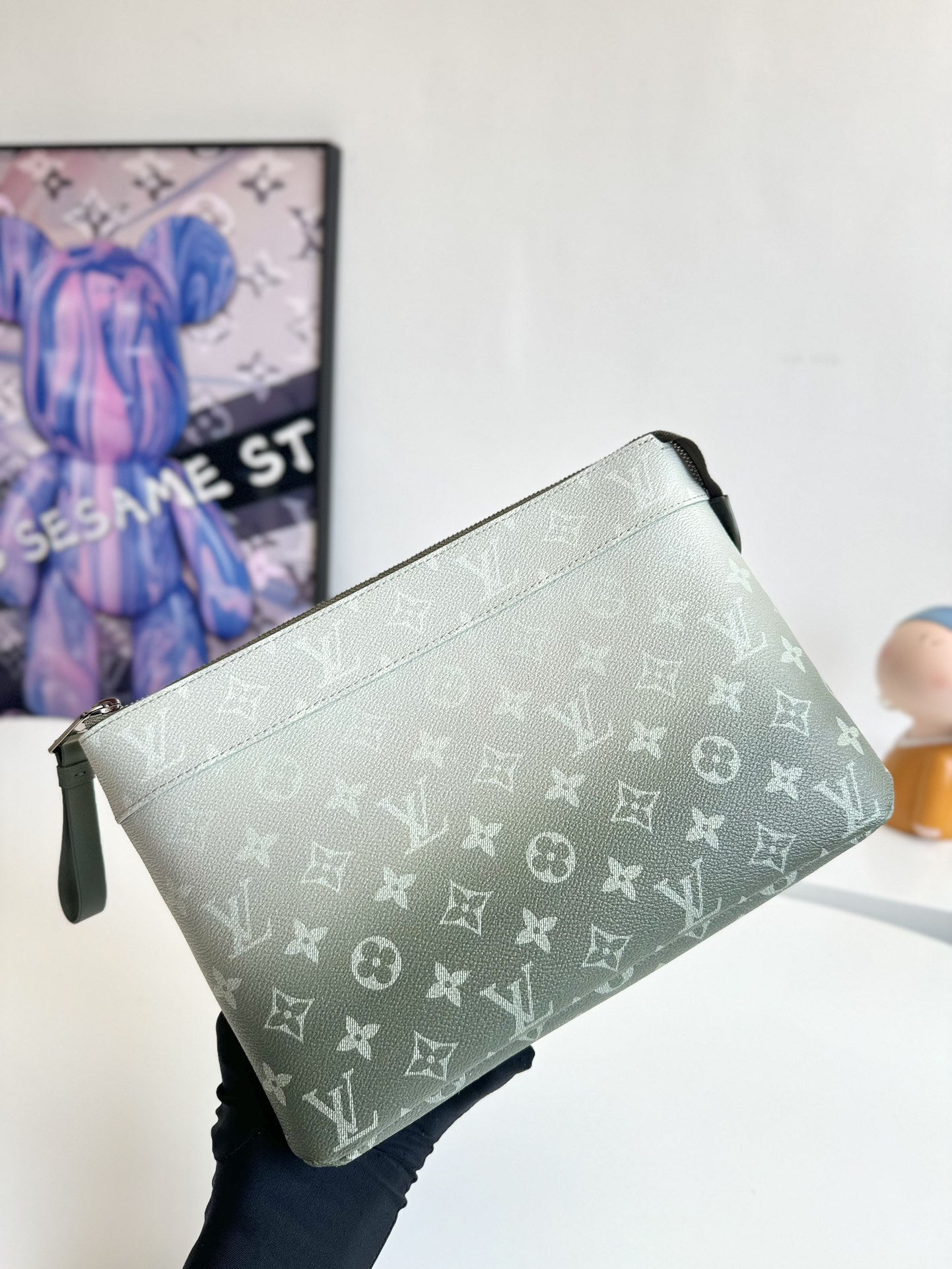 P700 M11545 Este bolso de mano Pochette Voyage Souple está confeccionado en lona Monclerogram Gradient y luce un estampado Monclerogram disperso hacia arriba. También se puede colocar en un bolso de mano para facilitar el transporte de sus necesidades diarias Tamaño: 30 x 21 x 7,5 cm.