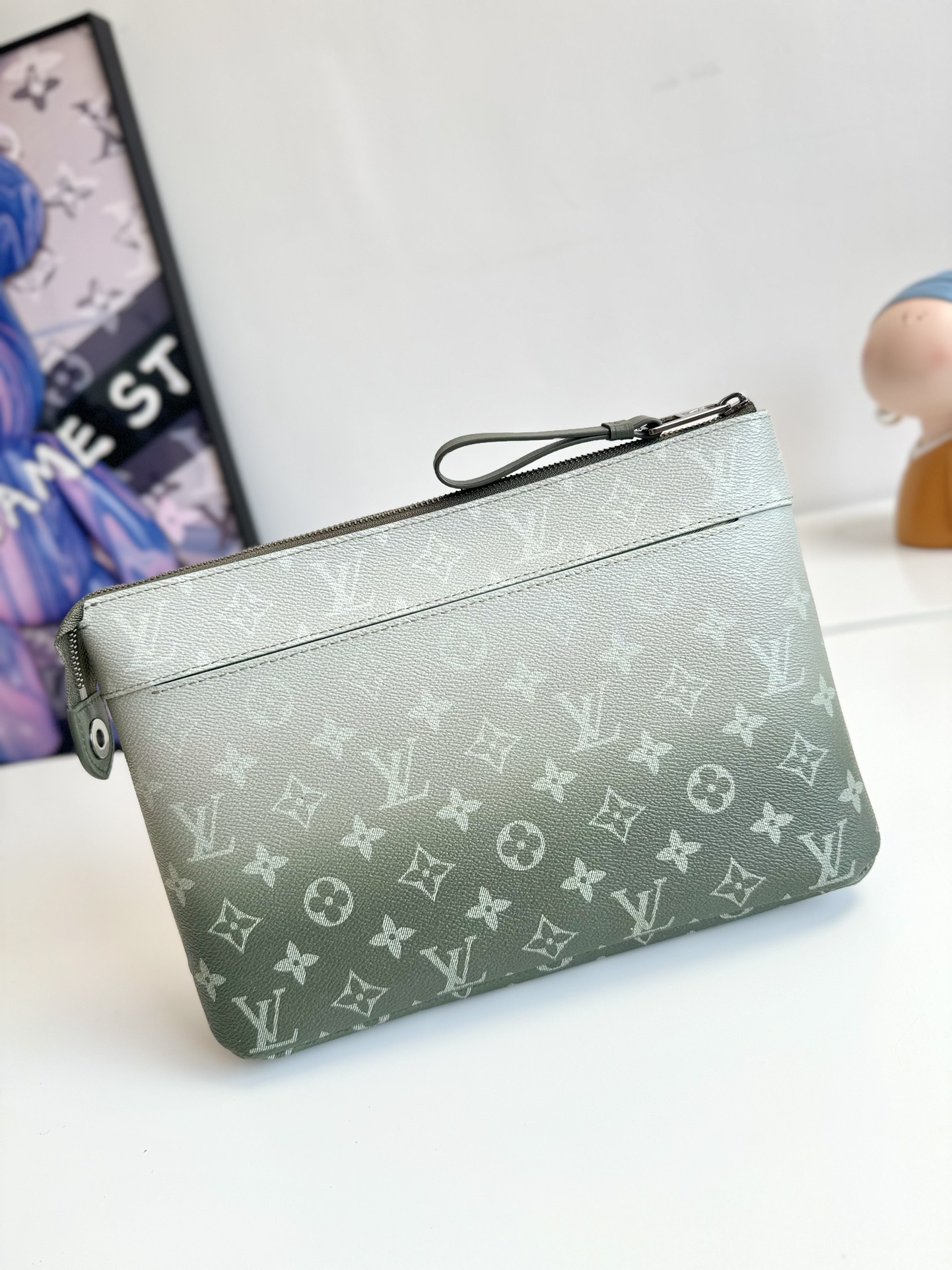 P700 M11545 This Pochette Voyage Souple clutch bag is made of Monclerogram Gradient canvas and features an upwardly dispersed Monclerogram pattern. It can also be placed in a handbag to make your daily necessities easy to carry around. Size: 30×21×7.5cm