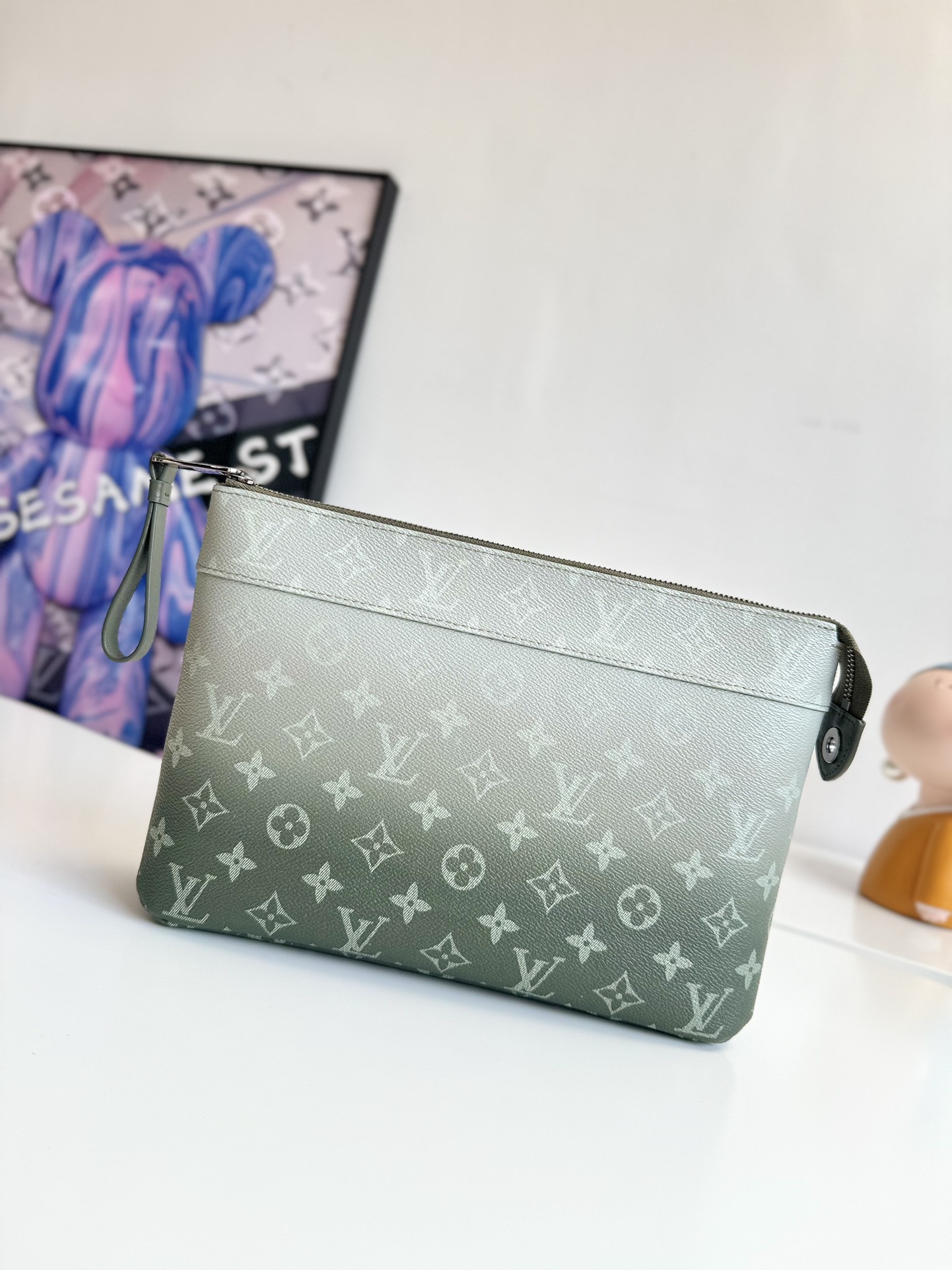 P700 M11545 This Pochette Voyage Souple clutch bag is made of Monclerogram Gradient canvas and features an upwardly dispersed Monclerogram pattern. It can also be placed in a handbag to make your daily necessities easy to carry around. Size: 30×21×7.5cm