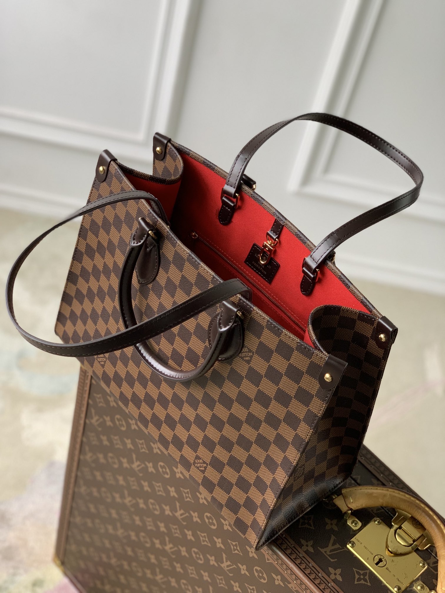 P1560 LV N00065أعيد تصميم حقيبة OnTheGo MM الكلاسيكية من قماش Damier Ebene وزُيّنت بجلد البقر الناعم مع قطع معدنية ذهبية اللون. يمكن حملها كحقيبة يد أو كحقيبة كتف بمقابض أطول. يأتي التصميم المتطور بجيب داخلي واحد وبسعة كبيرة لتخزين الكمبيوتر المحمول والأساسيات اليومية الأخرى.35 × 27 × 14 سم(الطول × الارتفاع × العرض)