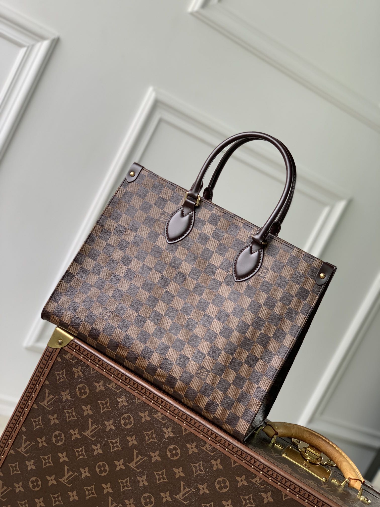 P1560 LV N00065أعيد تصميم حقيبة OnTheGo MM الكلاسيكية من قماش Damier Ebene وزُيّنت بجلد البقر الناعم مع قطع معدنية ذهبية اللون. يمكن حملها كحقيبة يد أو كحقيبة كتف بمقابض أطول. يأتي التصميم المتطور بجيب داخلي واحد وبسعة كبيرة لتخزين الكمبيوتر المحمول والأساسيات اليومية الأخرى.35 × 27 × 14 سم(الطول × الارتفاع × العرض)