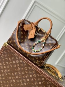 P1960 LV N87212El bolso Speedy Soft 30 Boho está confeccionado con la clásica lona recubierta de Monclerogram con un forro de piel y un bolsillo interior con cremallera para contrastes de colorLos adornos de piel de avestruz y la cadena de cuentas centran la atención en los ingeniosos detalles de la bolsa para llaves y la etiqueta de direcciónLas asas de torón permiten diversas opciones de transporte21 x 17 x 30 cm (Alto x Ancho x Largo) - Alto x Ancho x Largo réplica de bolsos de alta calidad