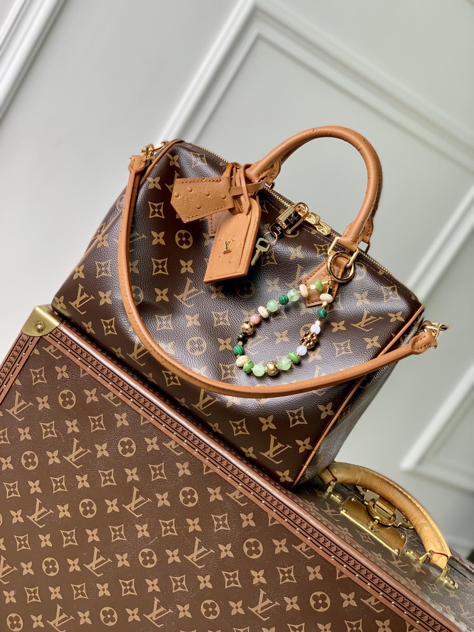 P1960 LV N87212The Speedy Soft 30 Boho bag is made of classic Monclerogram-coated canvas, with a leather lining and zippered interior pocket for a colorful contrast. Ostrich leather trim and beaded chain bring together the focal point of the bag, while a key ring and address tag create a clever detail. Toron handles allow for multiple carrying options.21 x 17 x 30 cm(H x W x L)