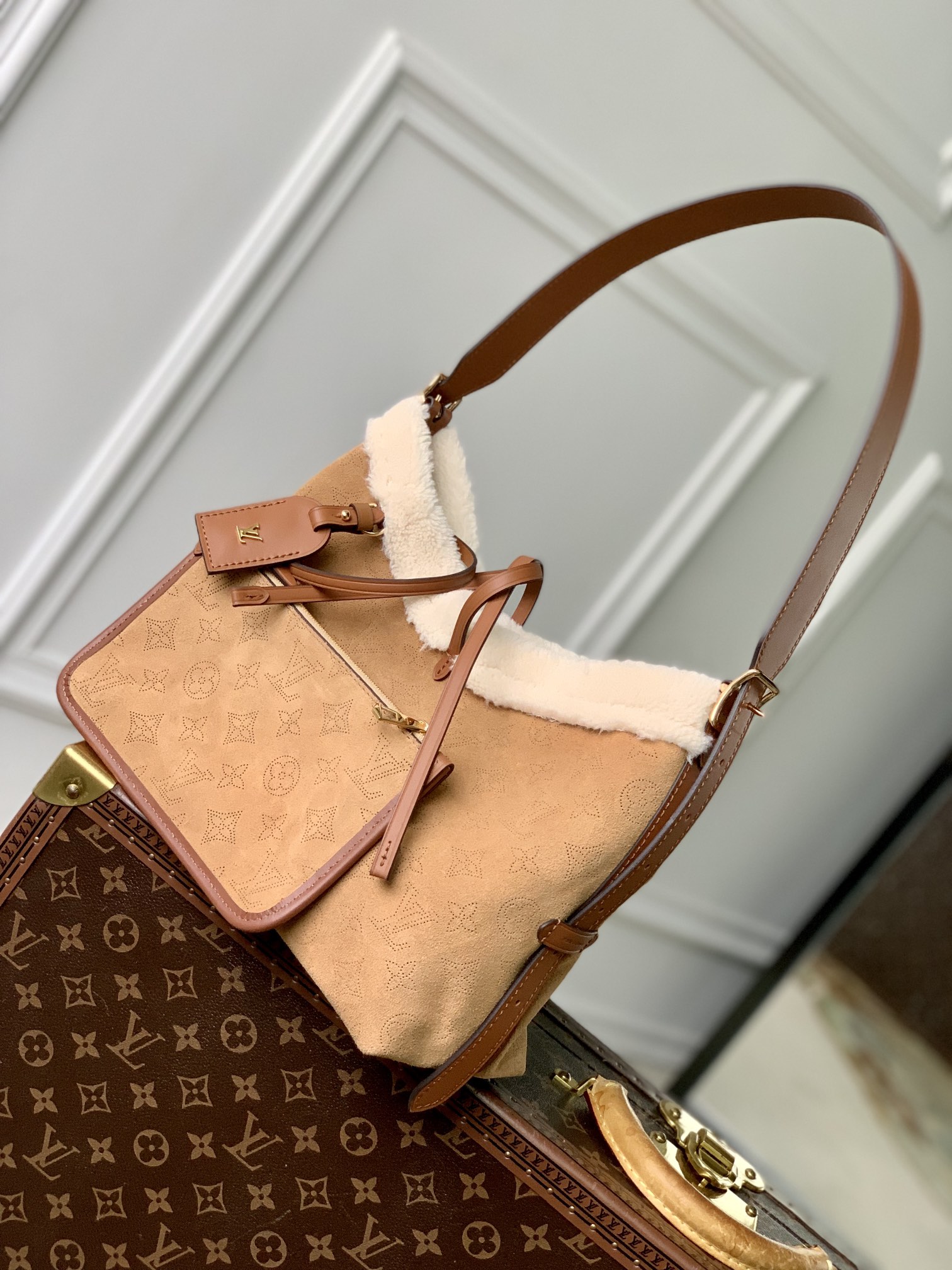 P2100 LV M11843Esta pequena mala de mão CarryAll da coleção LV Ski é fabricada em Monclerogram, uma camurça perfurada e transparente com um acabamento em pele de lã para um look quente de InvernoO fecho magnético e a alça em pele abrem bastante espaço para guardar facilmente um clipe de dinheiro comprido e os seus objectos essenciais diários24 x 12 x 29 cm (A x L x C)-Altas Bolsas Falsas