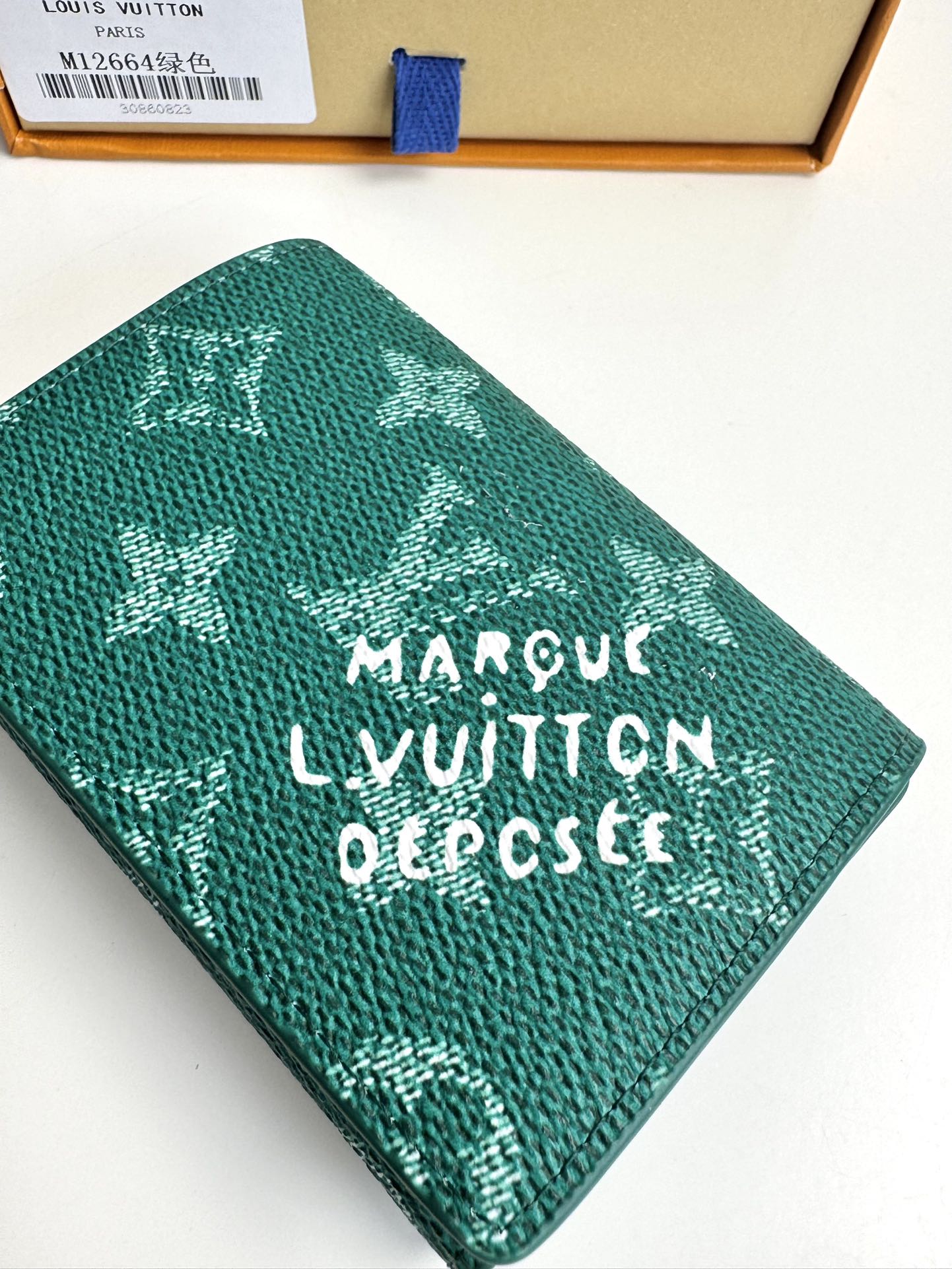 P320 M12664 Green This business card holder in Monclerogram Heritage canvas has a slim silhouette and can be easily slipped into a pocket or handbag flap. It opens with a hidden snap closure that reveals an organza compartment and card slots. Cowhide leather lining and the Marque L.Vuitton Déposée logo in Damier canvas add sophisticated detailing to the size: 10.5 x 8 x 1cm