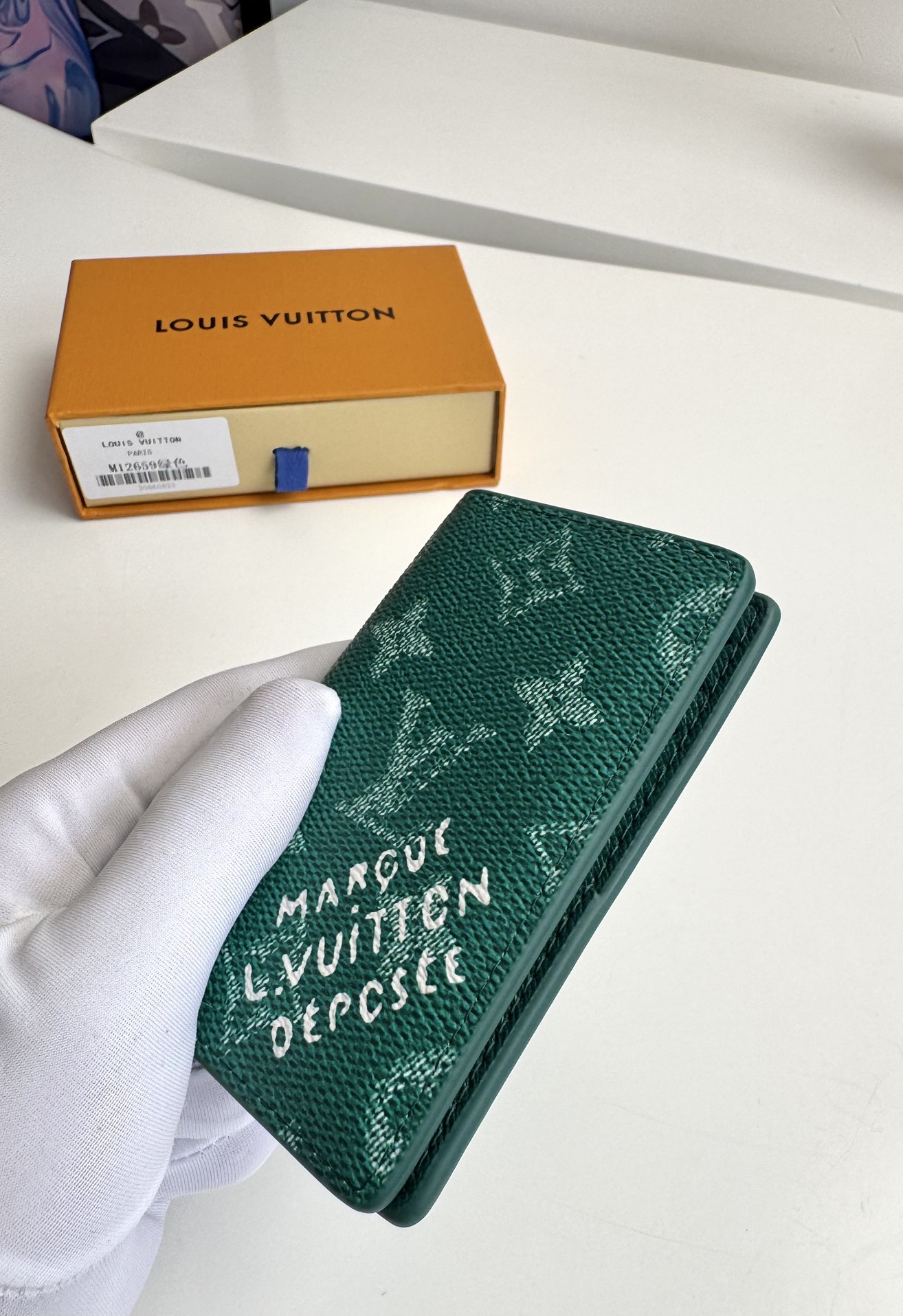 P280 M12659 Green This pocket wallet is made from Monclerogram Heritage coated canvas and features classic elements such as the Damier check and the Marque L. Vuitton Déposée logo, which showcases Pharrell Williams' modern interpretation of the Monclerogram pattern Dimensions. Dimensions: 11 x 7.5 x 1cm