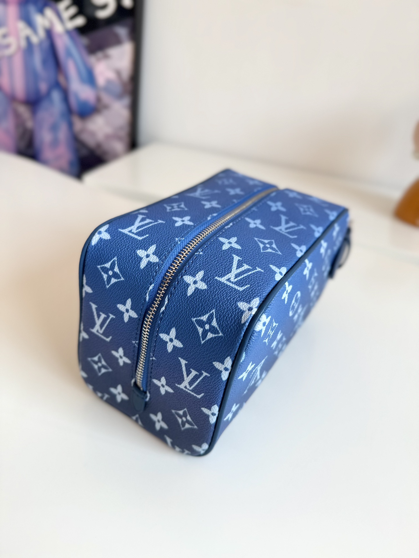 P720 M83112 NUEVO AZUL SEDA IMPRESO Este neceser Locker Dopp Kit está confeccionado en lona Monclerogram y es una mezcla de tendencias contemporáneas y elegancia. De forma compacta y con mucho espacio para guardar sus objetos de uso diario. El forro lavable combinado con las asas laterales ajustables facilitan su transporte.