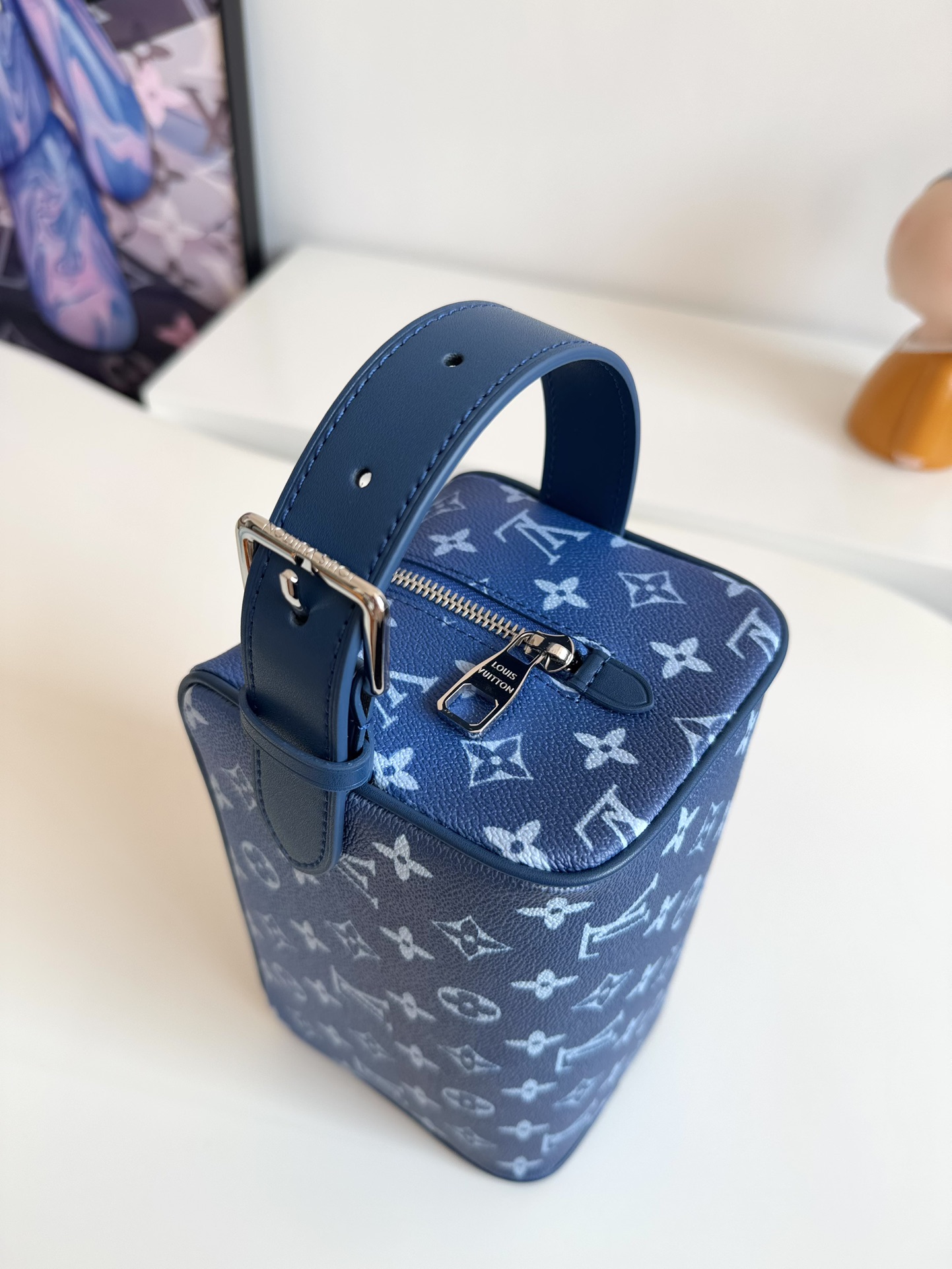 P720 M83112 NUEVO AZUL SEDA IMPRESO Este neceser Locker Dopp Kit está confeccionado en lona Monclerogram y es una mezcla de tendencias contemporáneas y elegancia. De forma compacta y con mucho espacio para guardar sus objetos de uso diario. El forro lavable combinado con las asas laterales ajustables facilitan su transporte.