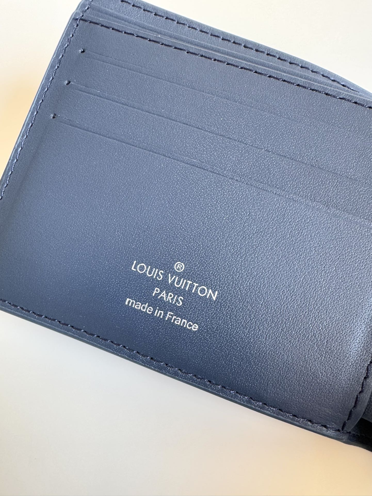 P300 M69829 Azul escuro LV Aerogram Multiple Wallet Uma nova abordagem a um design clássico, o trabalho artesanal desta carteira confere à pele de vaca uma textura granulada rica e as letras LV em metal marcam a identidade da marca, tornando-a fácil de usar com a gama de malas de mão LV Aerogram Dimensões: 11,5 x 9 x 1,5 cm