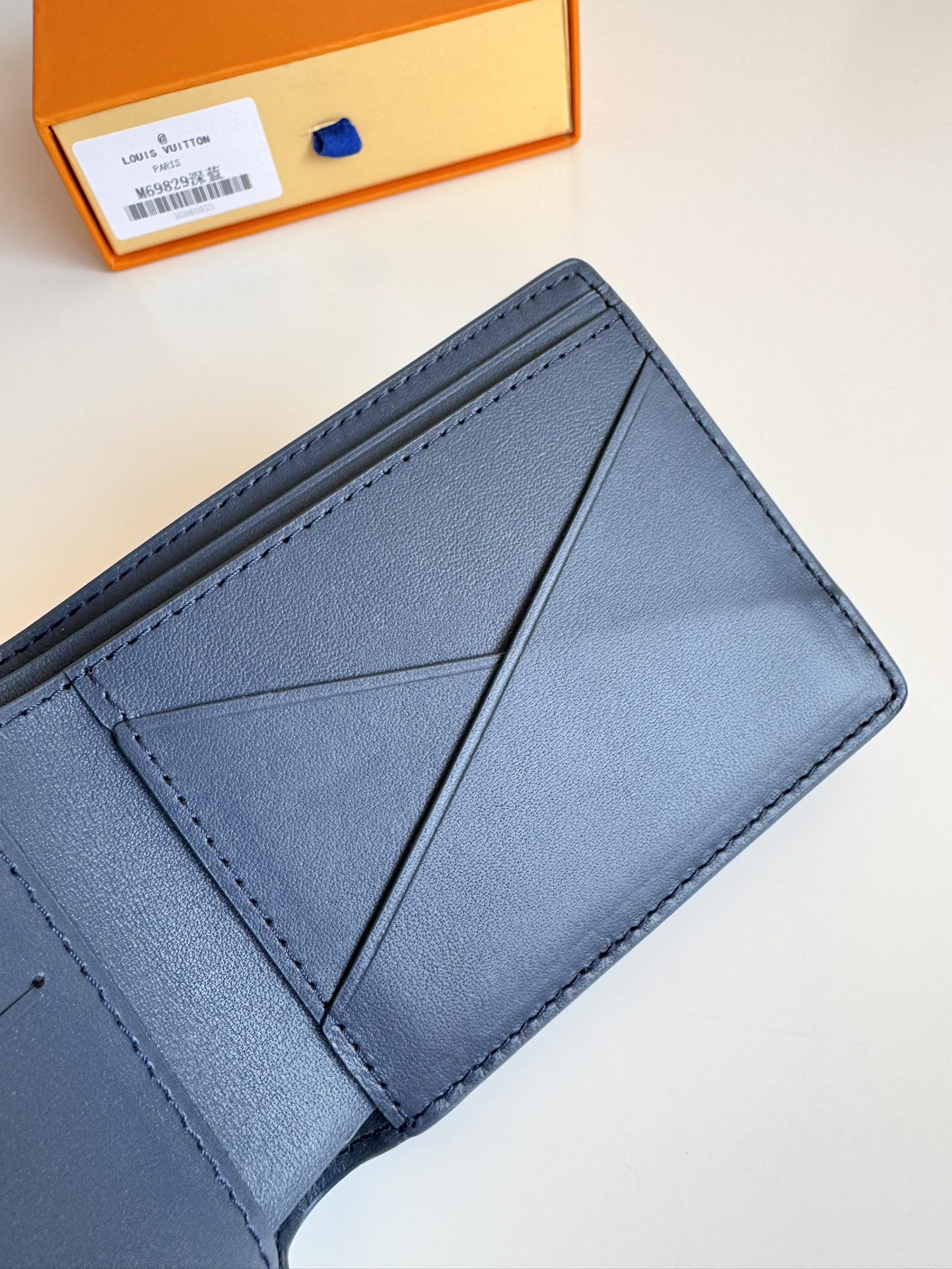 P300 M69829 Azul escuro LV Aerogram Multiple Wallet Uma nova abordagem a um design clássico, o trabalho artesanal desta carteira confere à pele de vaca uma textura granulada rica e as letras LV em metal marcam a identidade da marca, tornando-a fácil de usar com a gama de malas de mão LV Aerogram Dimensões: 11,5 x 9 x 1,5 cm