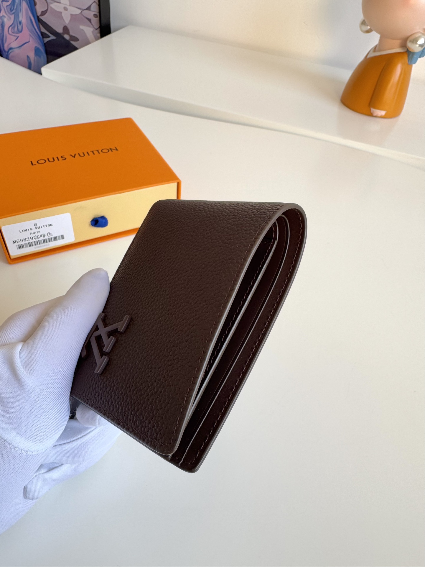 P300 M69829 Negro Cartera múltiple LV Aerogram Una visión fresca de un diseño clásico, la artesanía confiere a la piel de vacuno una rica textura granulada Las letras LV metálicas marcan la identidad de la marca y se pueden llevar fácilmente con la gama de bolsos LV Aerogram Dimensiones: 11,5 x 9 x 1,5cm