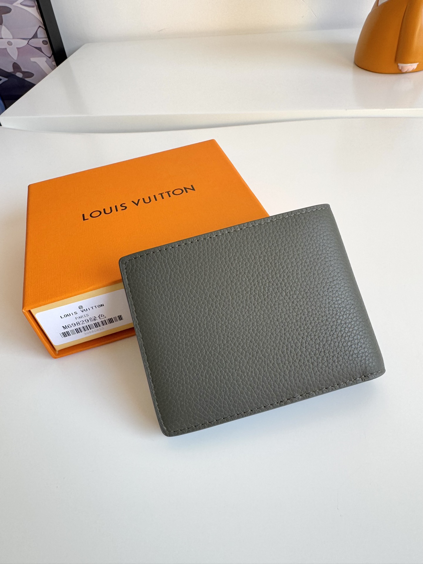 P300 M69829 Gray LV Aerogram Multiple Wallet A fresh take on a classic design, the craftsmanship gives the cowhide leather a richly grained texture Metal LV letters mark the brand's identity and can be easily worn with the LV Aerogram collection of handbags Dimensions: 11.5 x 9 x 1.5 cm.