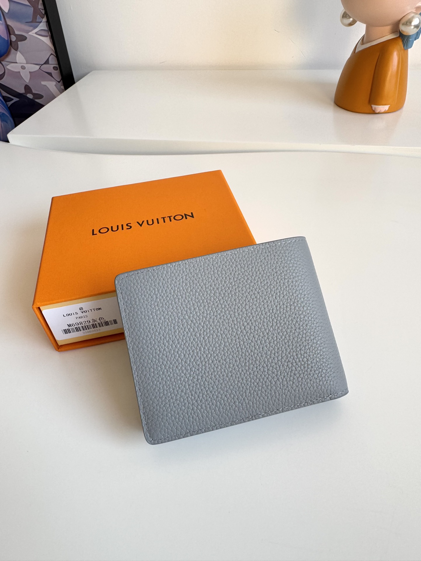 P300 M69829 Gray LV Aerogram Multiple Wallet A fresh take on a classic design, the craftsmanship gives the cowhide leather a richly grained texture Metal LV letters mark the brand's identity and can be easily worn with the LV Aerogram collection of handbags Dimensions: 11.5 x 9 x 1.5 cm.