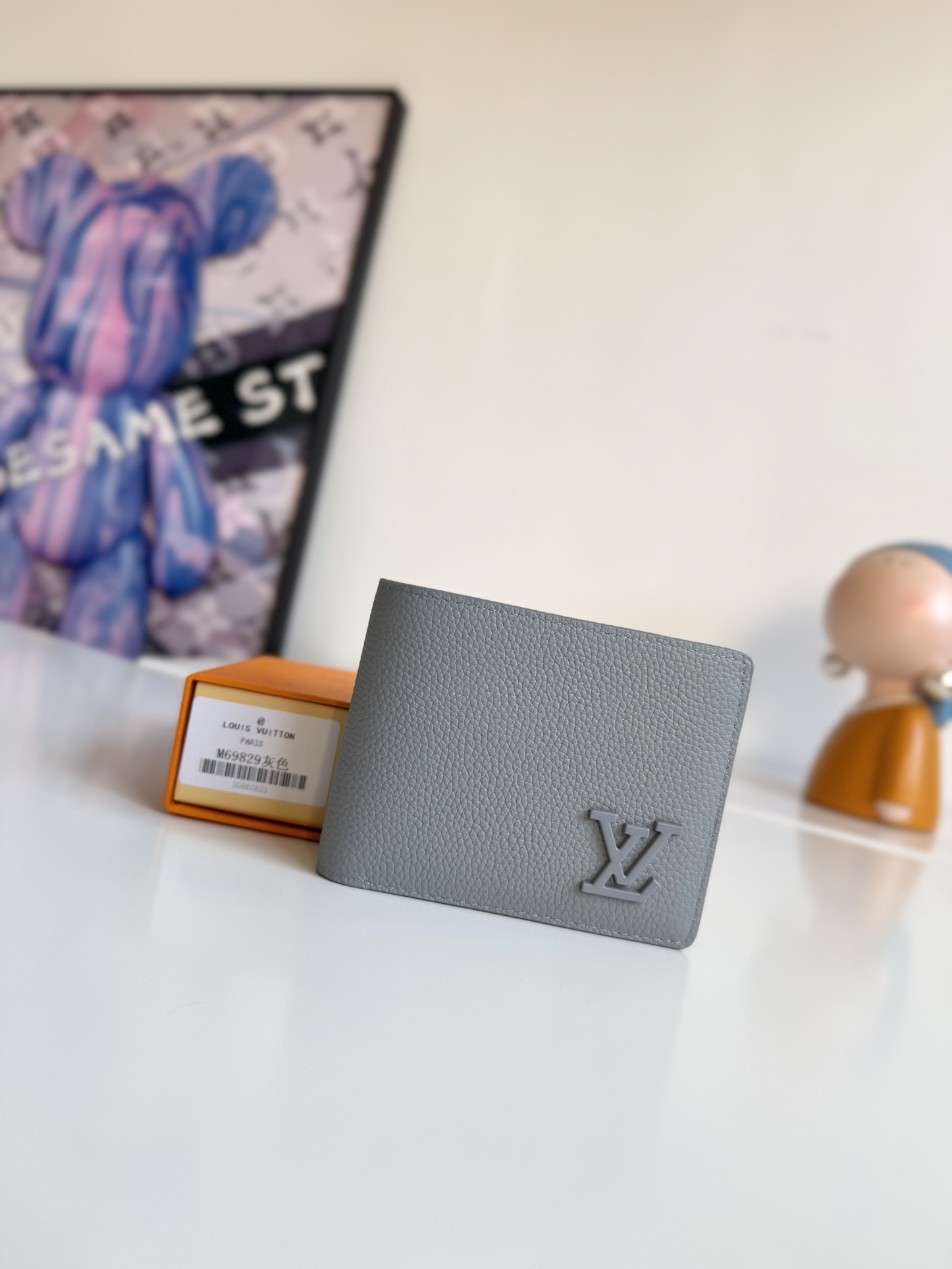 P300 M69829 Gray LV Aerogram Multiple Wallet A fresh take on a classic design, the craftsmanship gives the cowhide leather a richly grained texture Metal LV letters mark the brand's identity and can be easily worn with the LV Aerogram collection of handbags Dimensions: 11.5 x 9 x 1.5 cm.