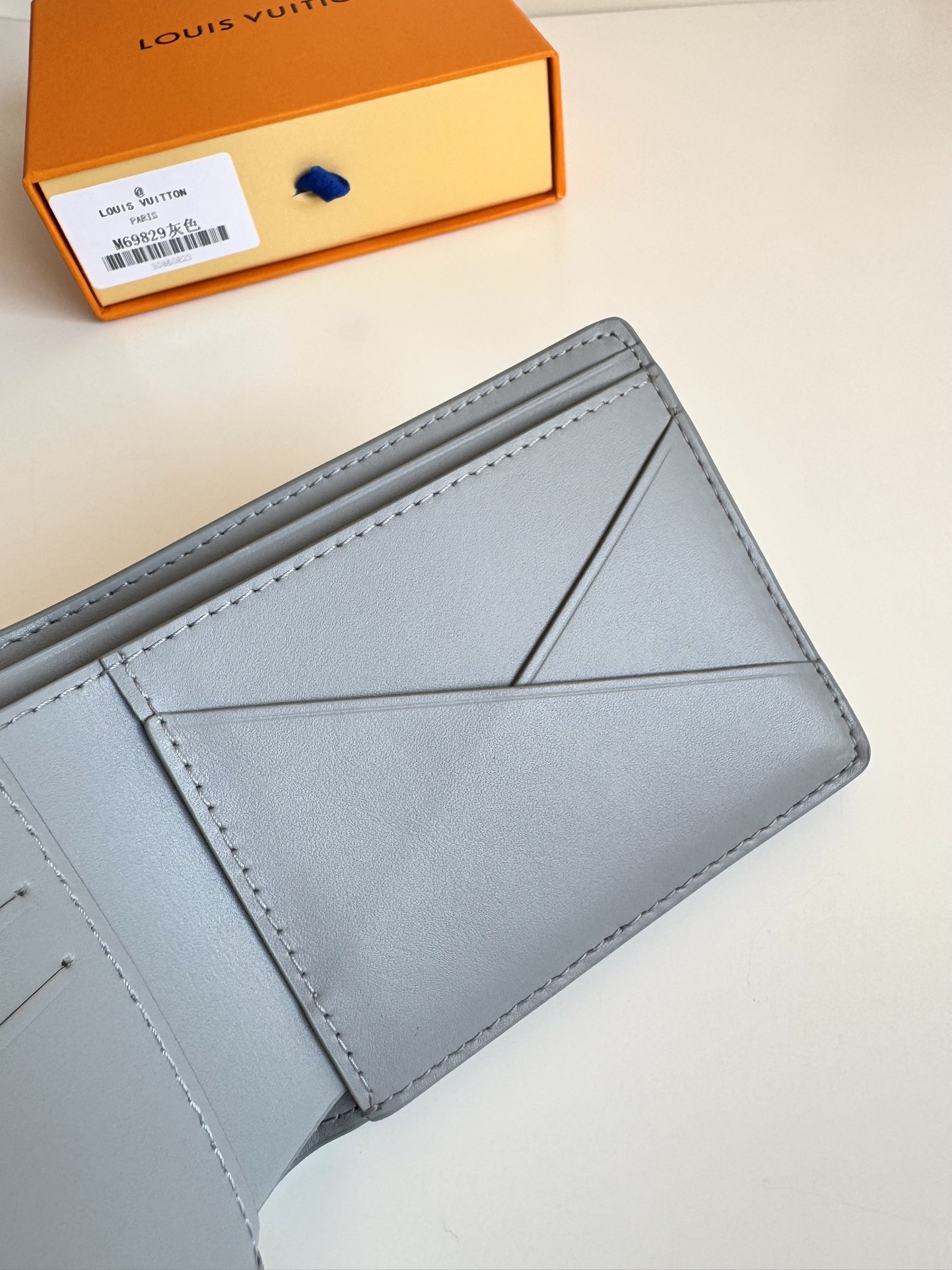 P300 M69829 Gray LV Aerogram Multiple Wallet A fresh take on a classic design, the craftsmanship gives the cowhide leather a richly grained texture Metal LV letters mark the brand's identity and can be easily worn with the LV Aerogram collection of handbags Dimensions: 11.5 x 9 x 1.5 cm.