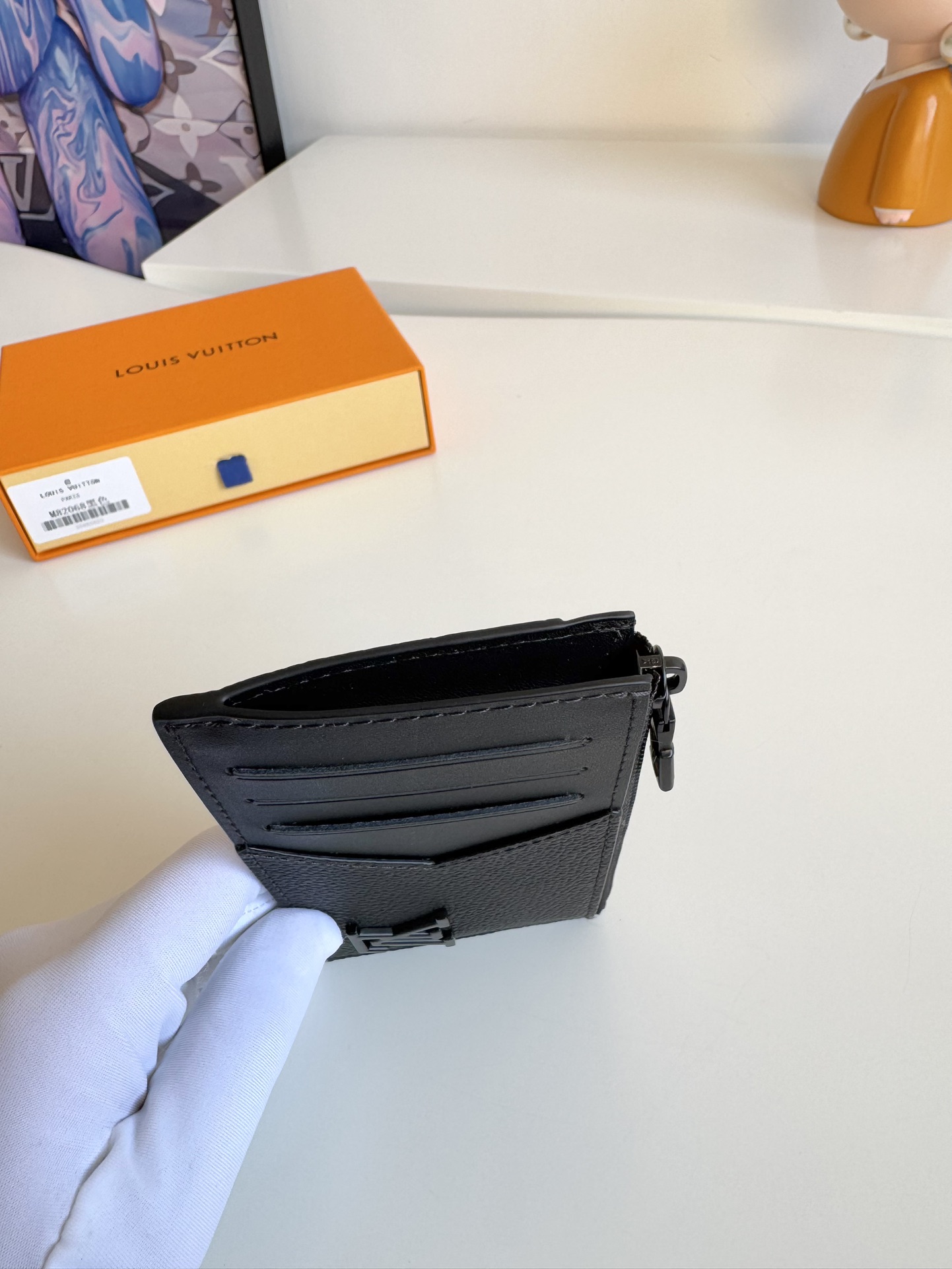 P360 M82068 Preto Feito à medida a partir da icónica pele Taiga da Louis Vuitton, o porta-cartões Coin tem um aspeto fino e elegante e é ideal para guardar em segurança trocos e notas. No interior, existem várias ranhuras para cartões de crédito e compartimentos para notas, bem como um bolso adicional com fecho para moedas.