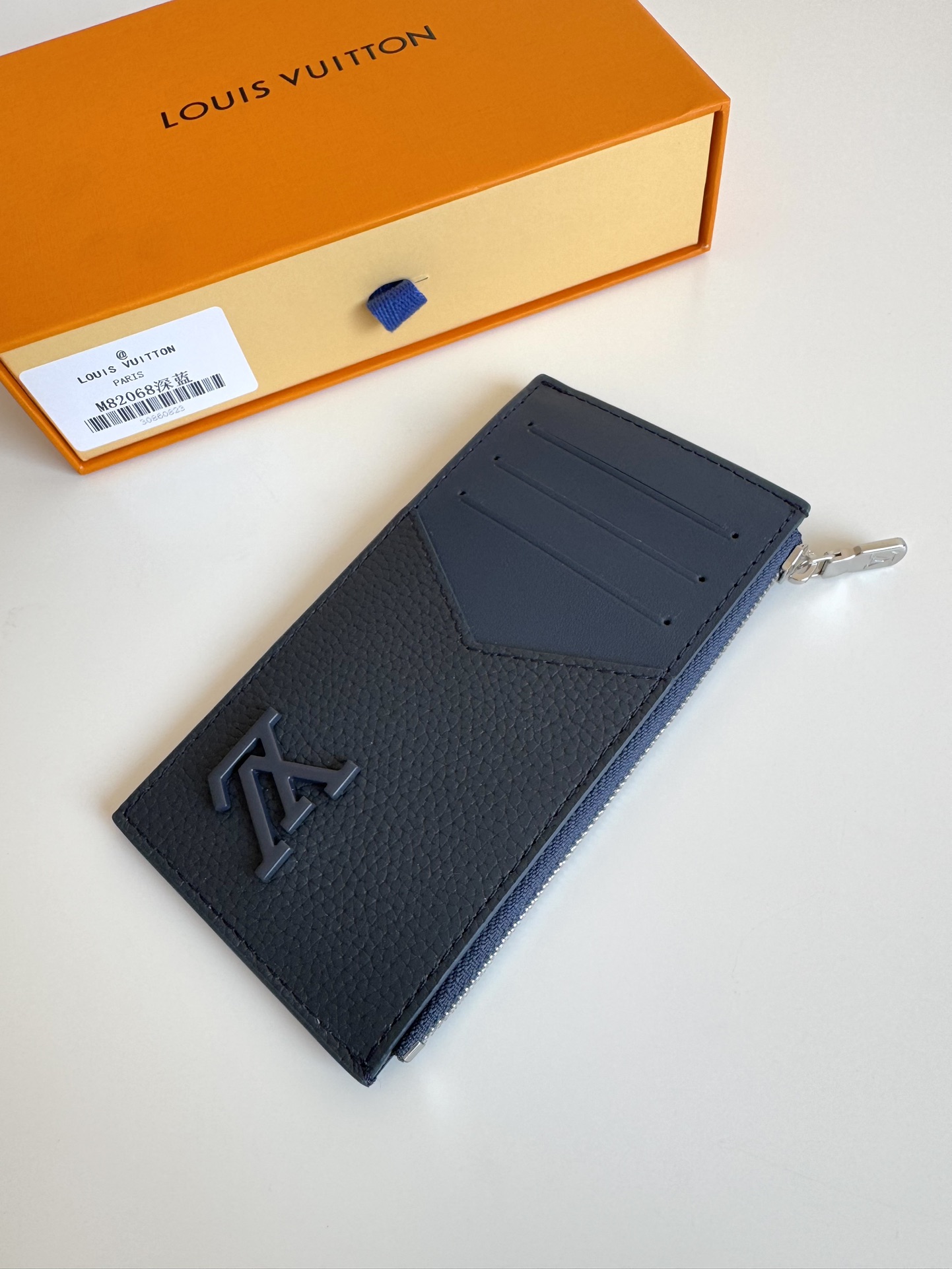 P360 M82068 Lake Blue Tailored from Louis Vuitton's iconic Taiga leather, the Coin card holder has a slim, clean look and is ideal for securely storing loose change and banknotes. Inside, there are multiple credit card slots and bill compartments, plus an additional zippered coin pocket.