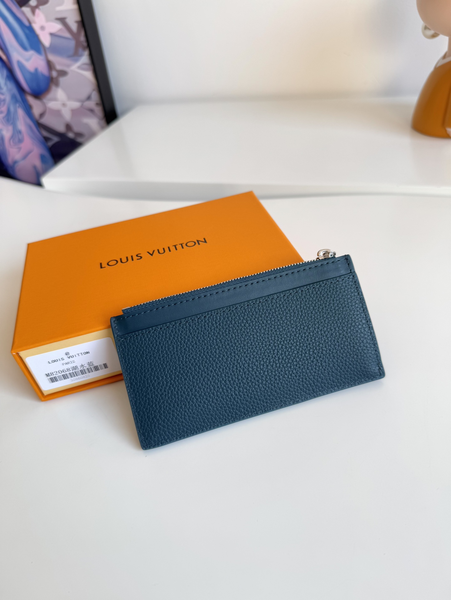 P360 M82068 Lake Blue Tailored from Louis Vuitton's iconic Taiga leather, the Coin card holder has a slim, clean look and is ideal for securely storing loose change and banknotes. Inside, there are multiple credit card slots and bill compartments, plus an additional zippered coin pocket.