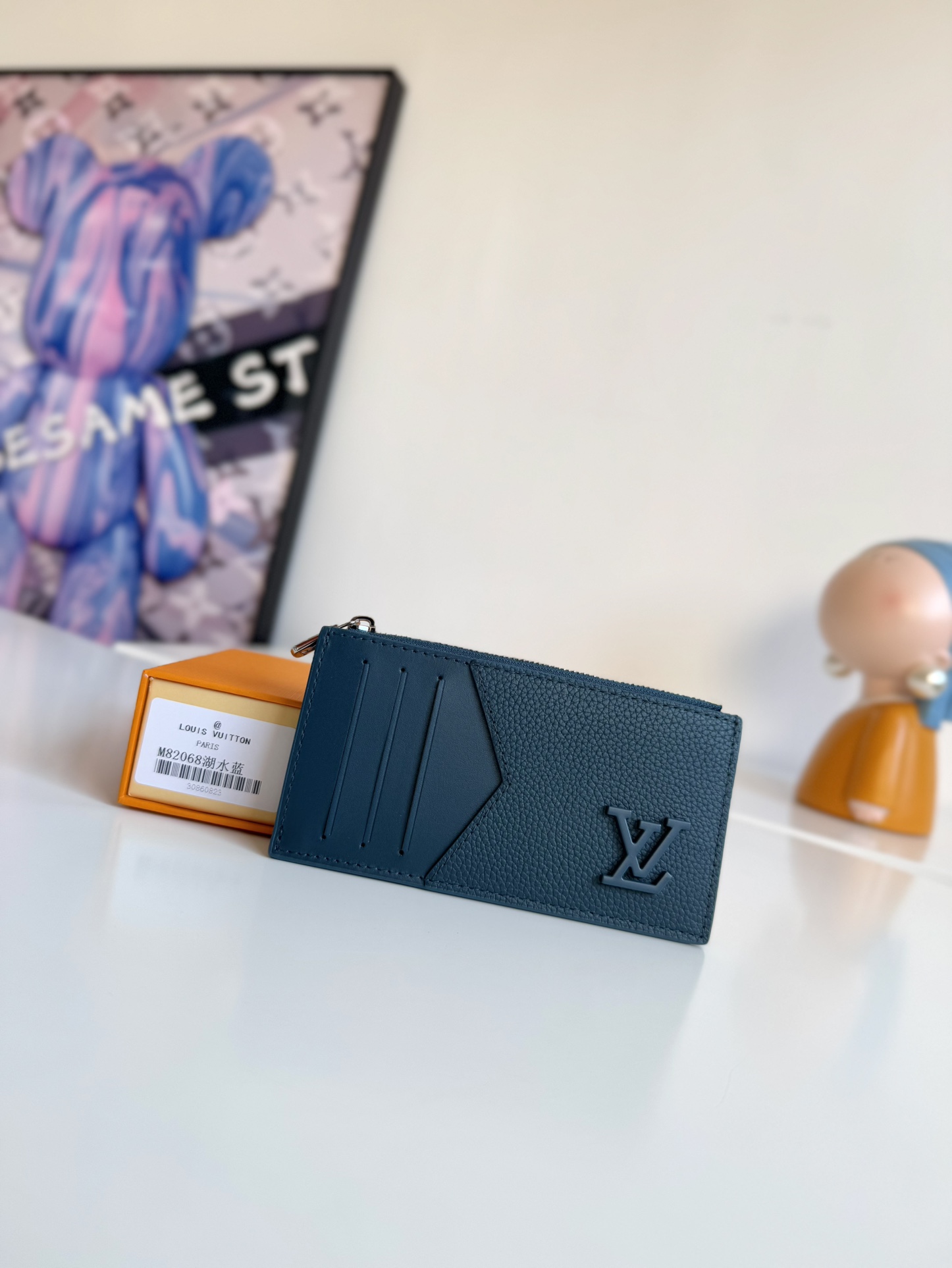 P360 M82068 Lake Blue Tailored from Louis Vuitton's iconic Taiga leather, the Coin card holder has a slim, clean look and is ideal for securely storing loose change and banknotes. Inside, there are multiple credit card slots and bill compartments, plus an additional zippered coin pocket.