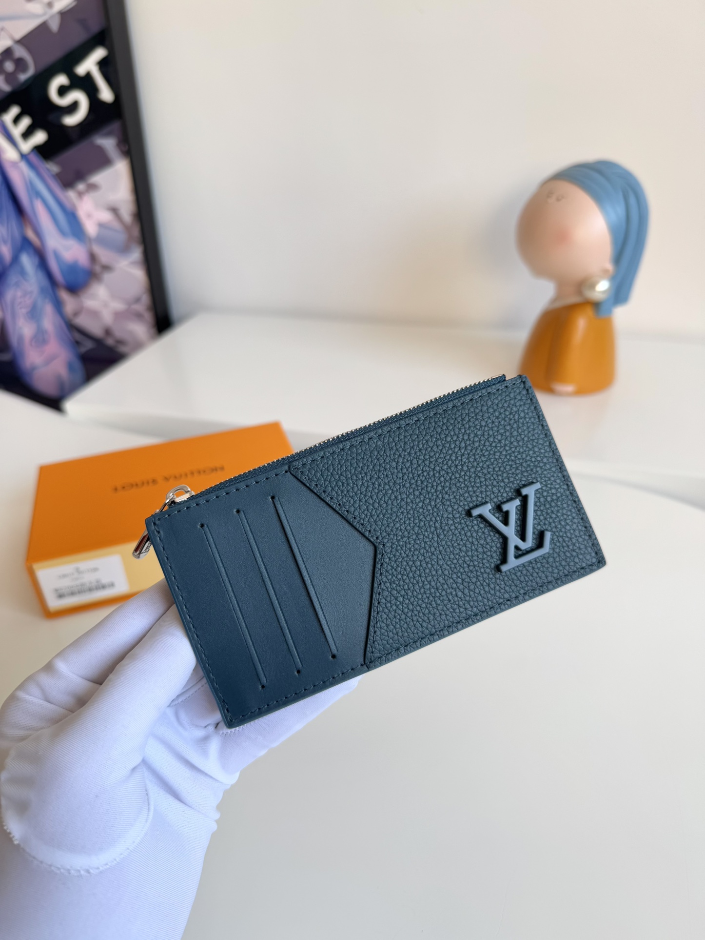 P360 M82068 Lake Blue Tailored from Louis Vuitton's iconic Taiga leather, the Coin card holder has a slim, clean look and is ideal for securely storing loose change and banknotes. Inside, there are multiple credit card slots and bill compartments, plus an additional zippered coin pocket.