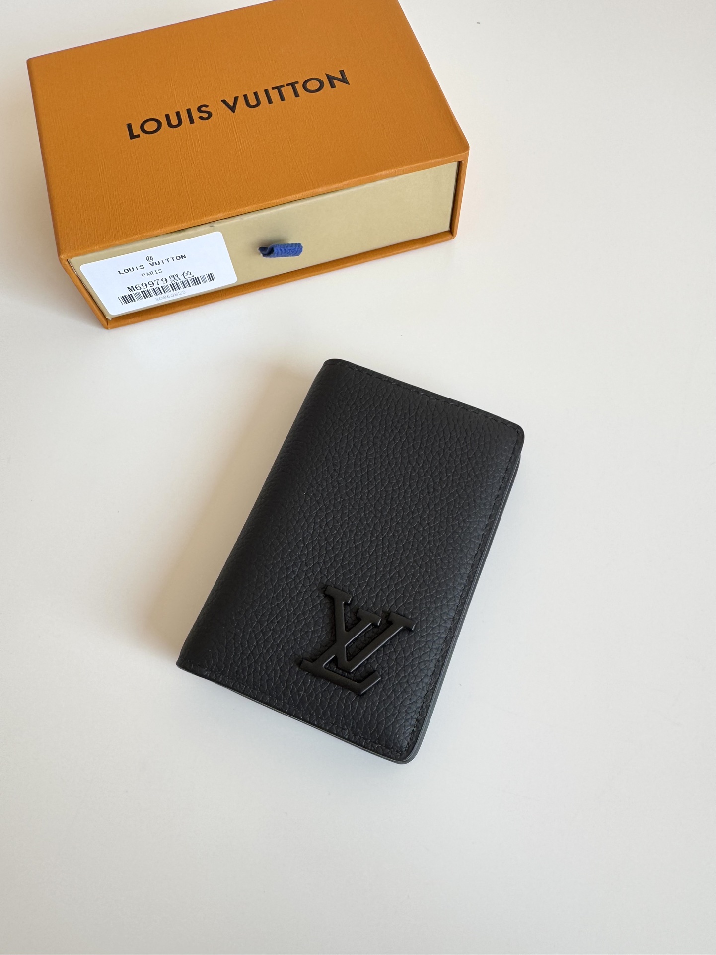 P280 M69979Negro Nuevo LV Aerogram Pocket Money ClipLa piel de vacuno seleccionada es tan suave como el membrete de una antigua aerolíneaLas letras LV metálicas subrayan la identidad de la marcaCon compartimentos y ranuras para tarjetas, es una fusión de elegancia y funcionalidad que puede combinarse con cualquiera de los bolsos de la colección Aerogram de LVMedidas: 11 x 8 cm.