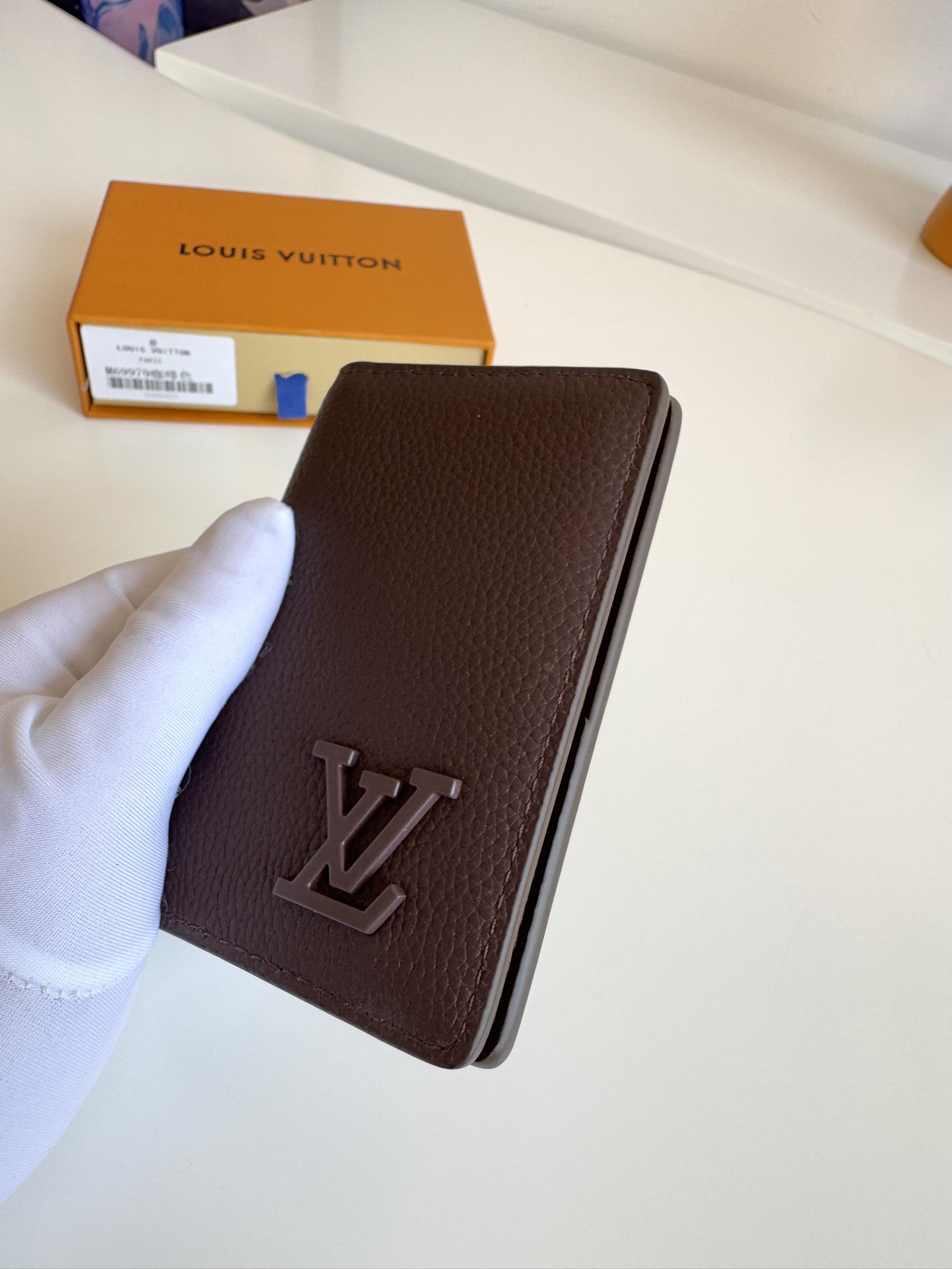 P280 M69979 Coffee New LV Aerogram Pocket Money Clip Selected cowhide leather is as soft as old-time airline letterhead Metal LV letters underline the brand's identity with compartments and card slots to achieve a fusion of elegance and functionality that can be worn with any of the LV Aerogram handbags Dimensions: 11 x 8 cm.