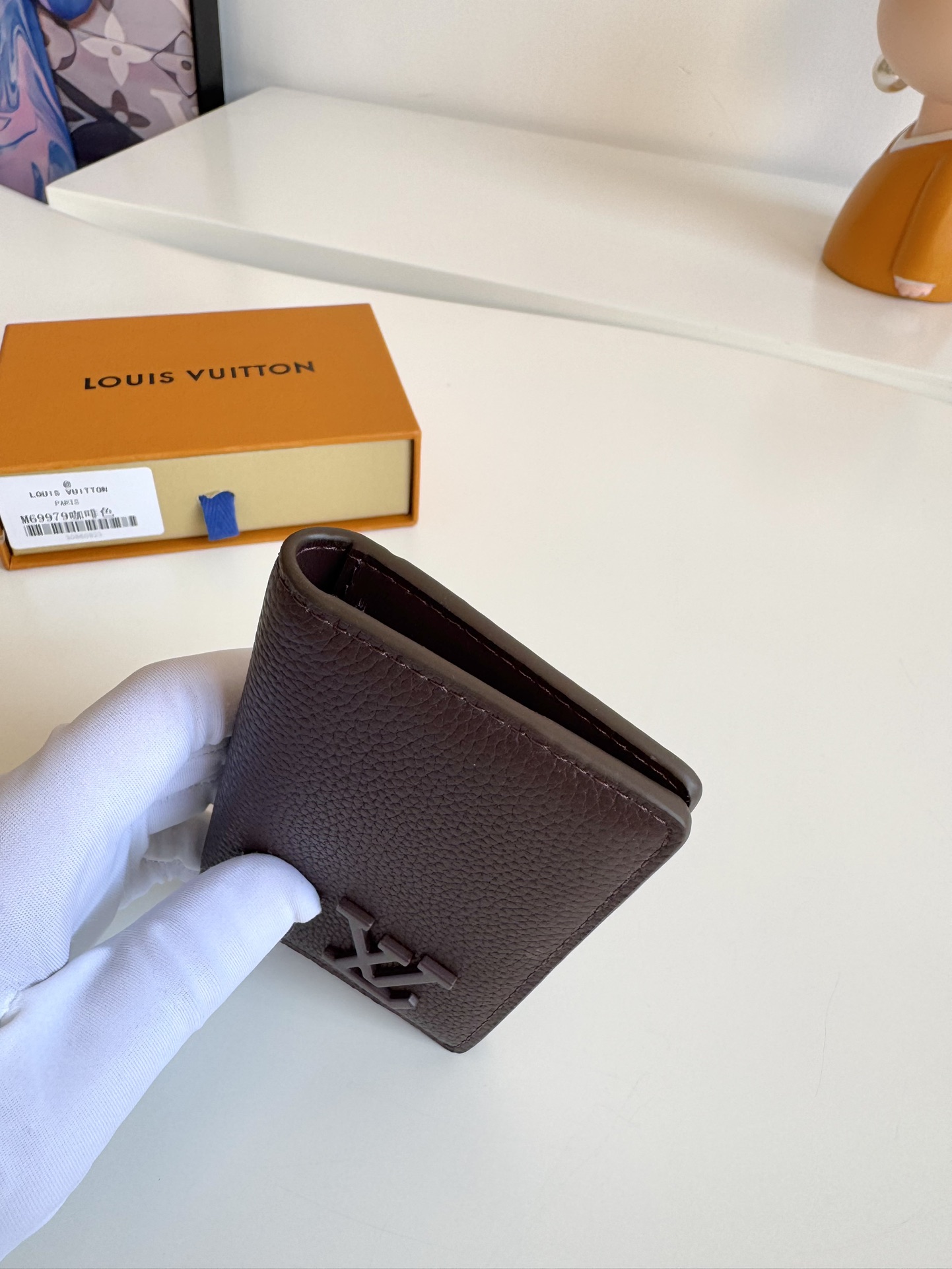 P280 M69979 Coffee Le nouveau portefeuille de poche LV Aerogram est fabriqué à partir d'une sélection de cuir de vachette aussi souple qu'un vieux papier à en-tête de compagnie aérienne. Les lettres LV en métal soulignent l'identité de la marque, avec des compartiments et des fentes pour cartes pour un mélange d'élégance et de fonctionnalité, et peut être associé à n'importe quel sac à main LV Aerogram.