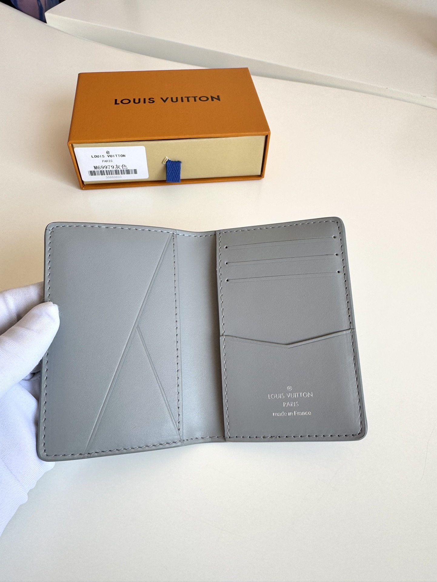 P280 M69979 Grey New LV Aerogram Pocket Money Clip Le cuir de vachette sélectionné est aussi doux qu'un vieux papier à en-tête de compagnie aérienne Les lettres LV en métal soulignent l'identité de la marque Avec des compartiments et des fentes pour cartes pour une fusion de l'élégance et de la fonctionnalité Peut être porté avec n'importe quel sac à main LV Aerogram Dimensions : 11 x 8 cm.