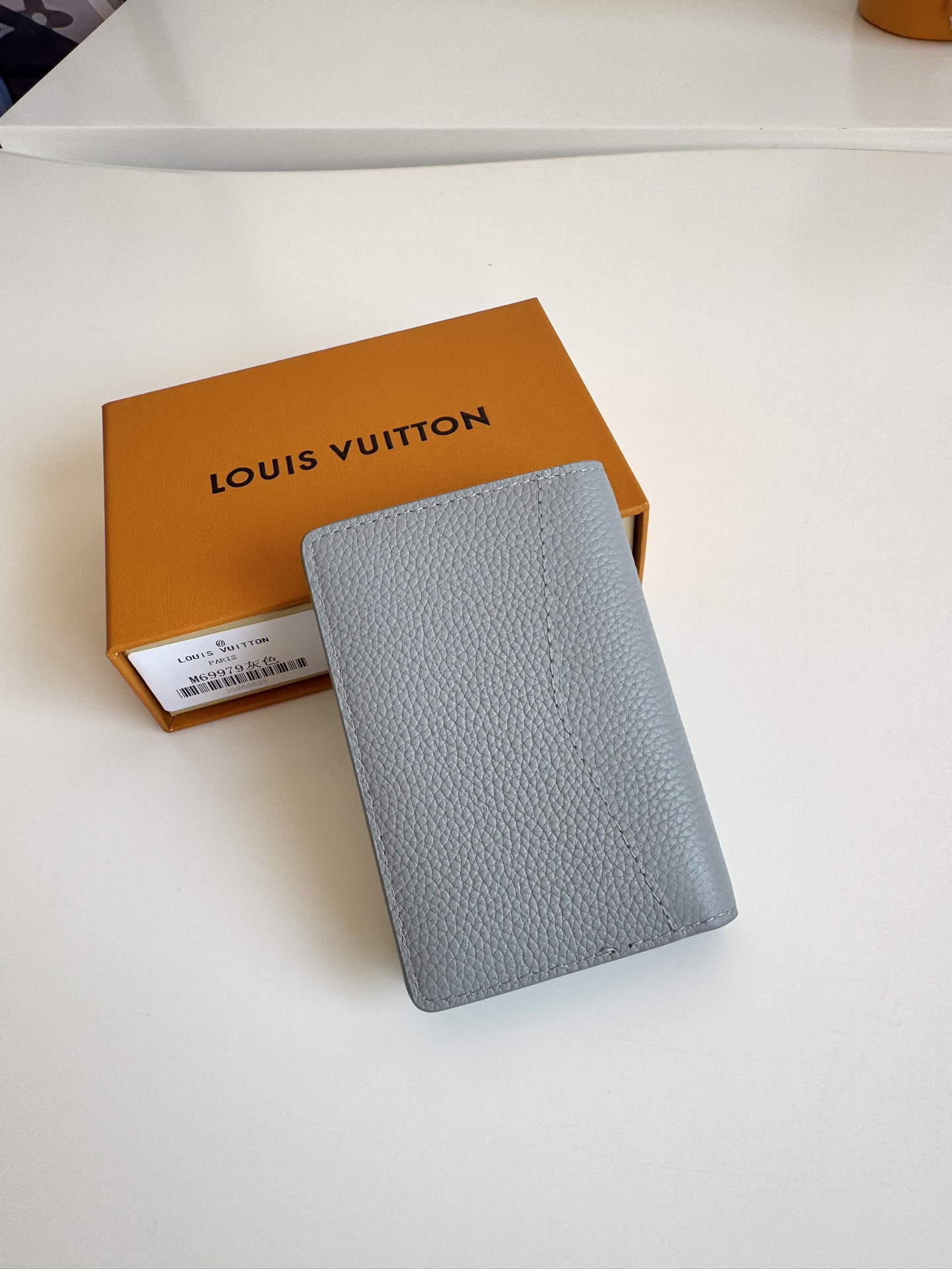 P280 M69979 Grey New LV Aerogram Pocket Money Clip Le cuir de vachette sélectionné est aussi doux qu'un vieux papier à en-tête de compagnie aérienne Les lettres LV en métal soulignent l'identité de la marque Avec des compartiments et des fentes pour cartes pour une fusion de l'élégance et de la fonctionnalité Peut être porté avec n'importe quel sac à main LV Aerogram Dimensions : 11 x 8 cm.