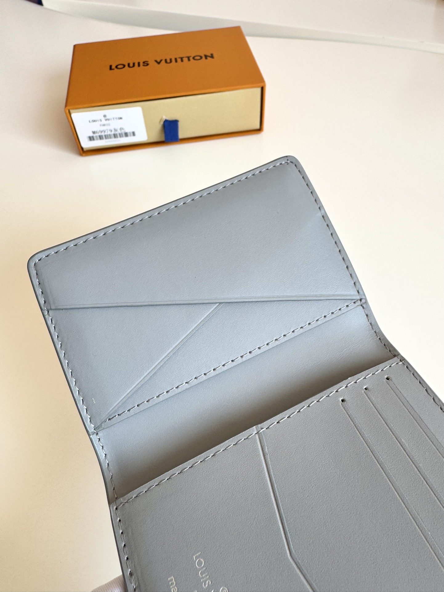 P280 M69979 Grey New LV Aerogram Pocket Money Clip Le cuir de vachette sélectionné est aussi doux qu'un vieux papier à en-tête de compagnie aérienne Les lettres LV en métal soulignent l'identité de la marque Avec des compartiments et des fentes pour cartes pour une fusion de l'élégance et de la fonctionnalité Peut être porté avec n'importe quel sac à main LV Aerogram Dimensions : 11 x 8 cm.