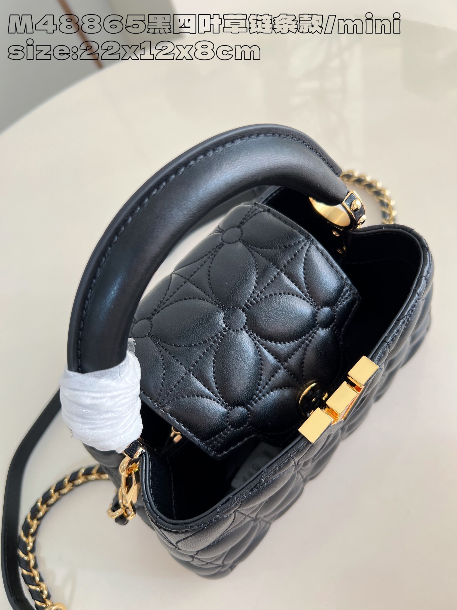 P2200 LV M48865 Black Clover Chain Clause/Mini Ce mini sac à main Capucines East-West est réalisé en cuir de crocodile avec une finition polie et glamourLuxueuse doublure en cuir de chèvre avec des accessoires en métal brillantPatte Capucines spéciale qui peut être rangée à l'intérieur du sac pour afficher le monogramme ou déployée22 x 12 x 8 cm (L x H x L)