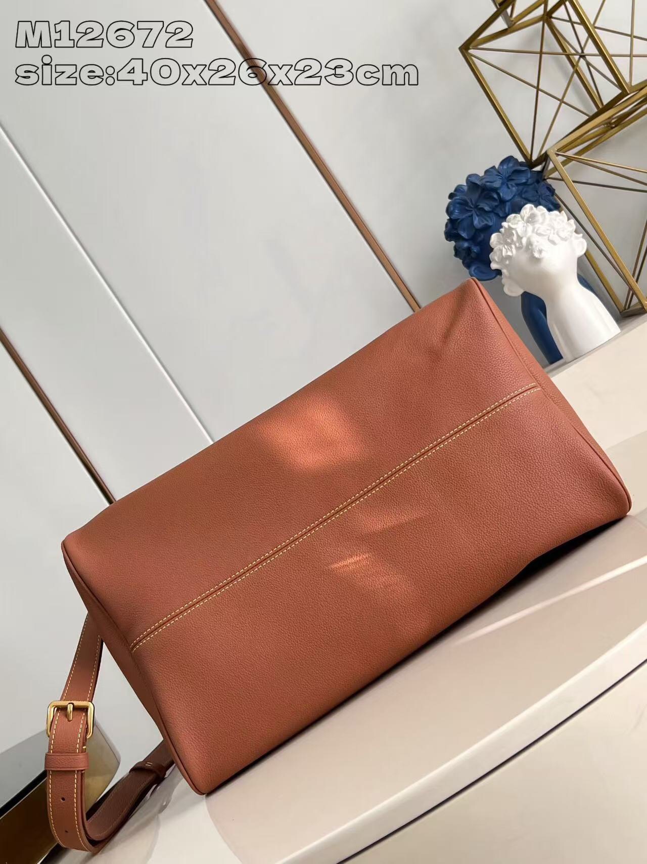 P2100 M12672 Marrón Este lujoso bolso Speedy Bandoulière 40 está confeccionado en piel de ternero ultrasuave y cuenta con un rico forro de piel de cordero de color coñac Incluye una bolsa de piel desmontable Dos asas superiores enrolladas de piel y una correa para el hombro desmontable y ajustable Para unas opciones de transporte versátiles Tamaño: 40x26x23cm