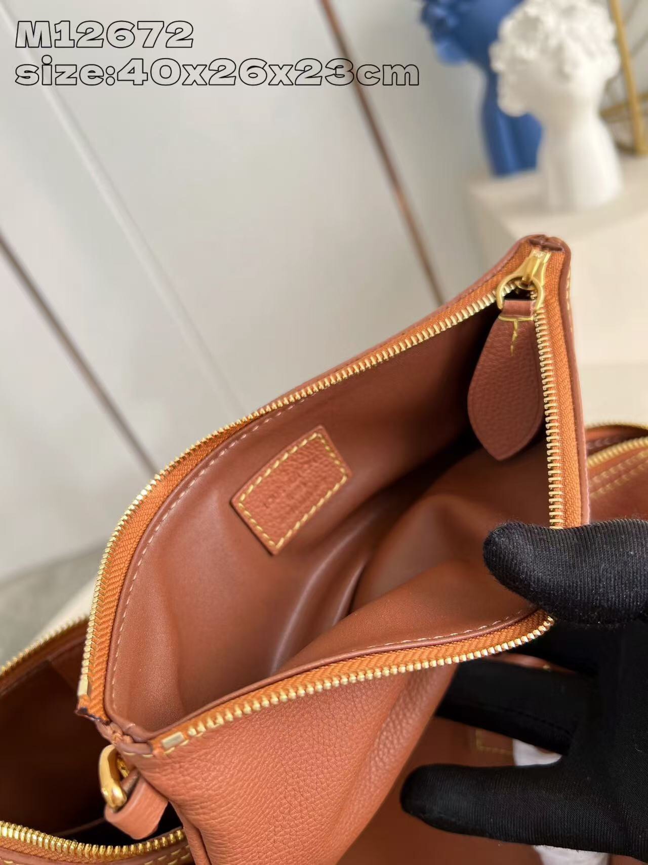 P2100 M12672 Marrón Este lujoso bolso Speedy Bandoulière 40 está confeccionado en piel de ternero ultrasuave y cuenta con un rico forro de piel de cordero de color coñac Incluye una bolsa de piel desmontable Dos asas superiores enrolladas de piel y una correa para el hombro desmontable y ajustable Para unas opciones de transporte versátiles Tamaño: 40x26x23cm